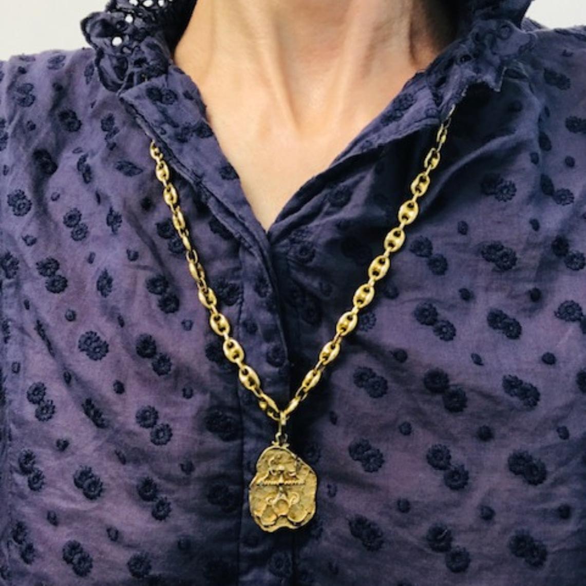 Collana con ciondolo Libra in oro 14k vintage con un ciondolo sospeso a una catena a maglie marinare a sbuffo. Il ciondolo misura circa 1 pollice per 1 pollice ed è realizzato in oro testurizzato con una silhouette irregolare. Il lato anteriore è