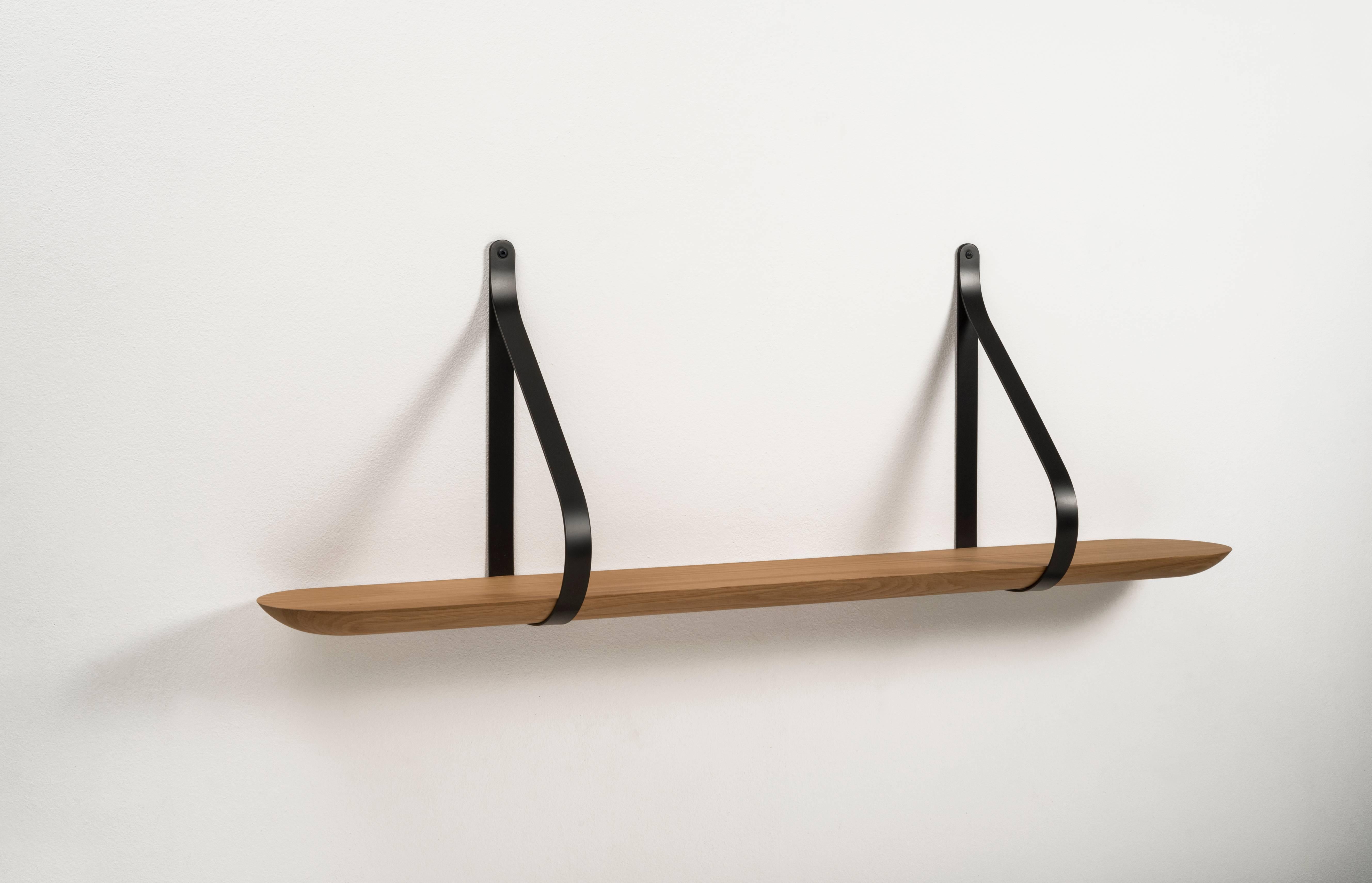 A Minimalist shape with a strong aesthetic. Made of solid oak oiled and supported by a iron stirrup. Inside the wooden shelf, a metal flat bar fixed to the support structure is hidden, in order to increase stability. Libra plays with the concept of