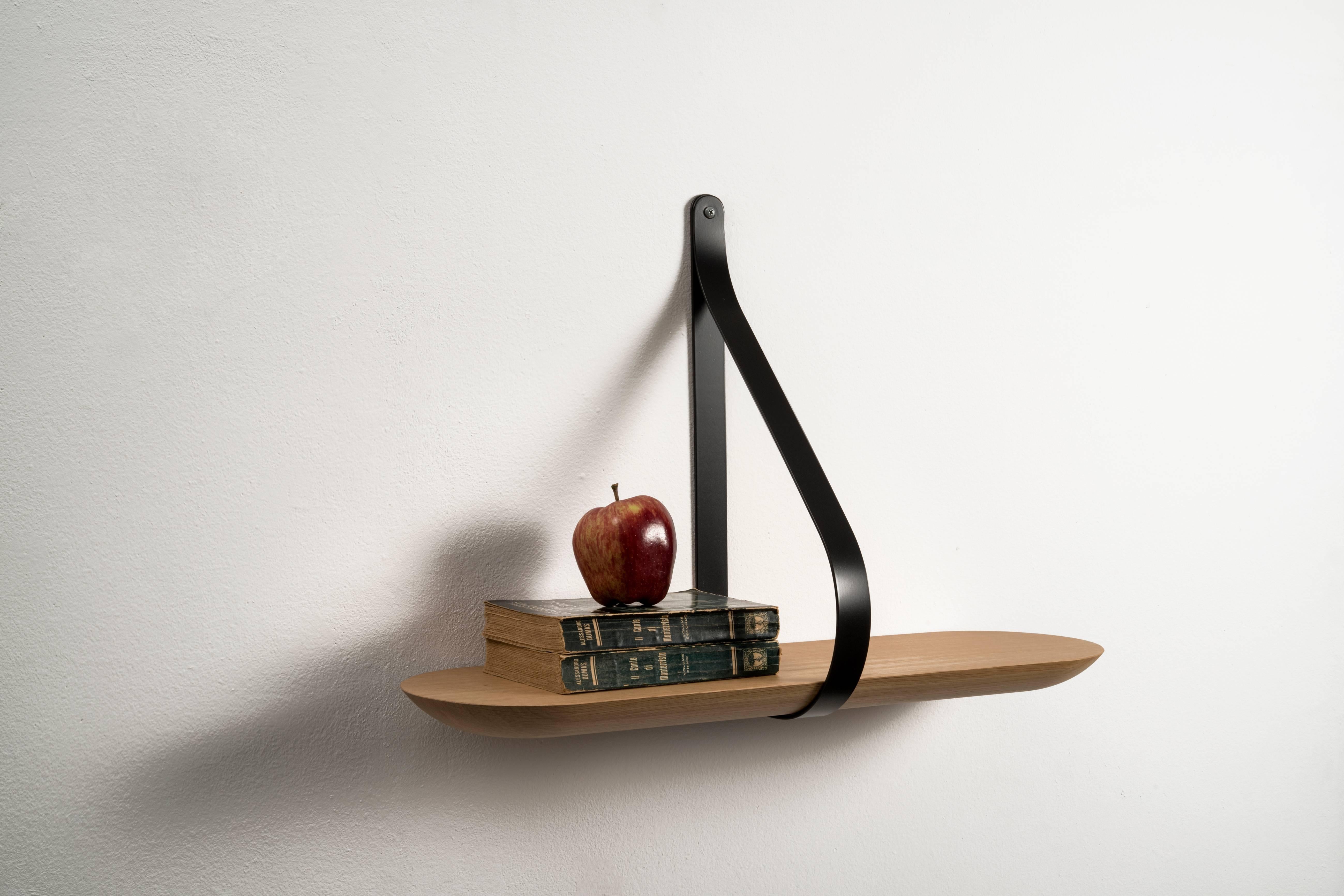 A minimalist shape with a strong aesthetic. Made of solid oak oiled and supported by a iron stirrup. Inside the wooden shelf, a metal flat bar fixed to the support structure is hidden, in order to increase stability. Libra plays with the concept of