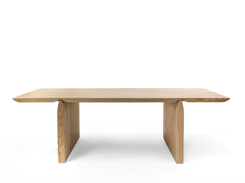Table entièrement en bois massif avec plateau en lamelles collées, à deux côtés droits, dont la forme s'inspire du monde de la nature et, plus particulièrement, de la forme d'une libellule.