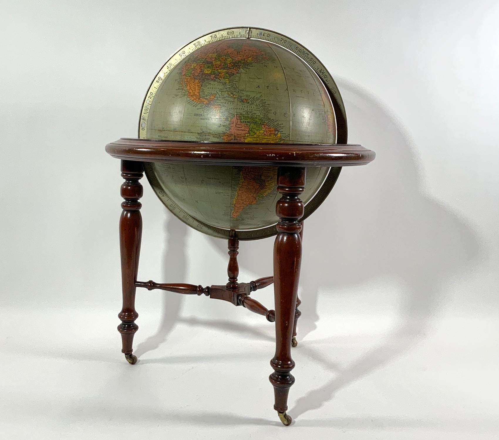 Library globe on quality mahogany stand with brass casters and ring. By Replogle of Chicago. Gustav Bruechmann, Cartographer. This has a lot of character but does have nicks and dings and scrapes as well as some inpainting. Great prop. Circa 1940.