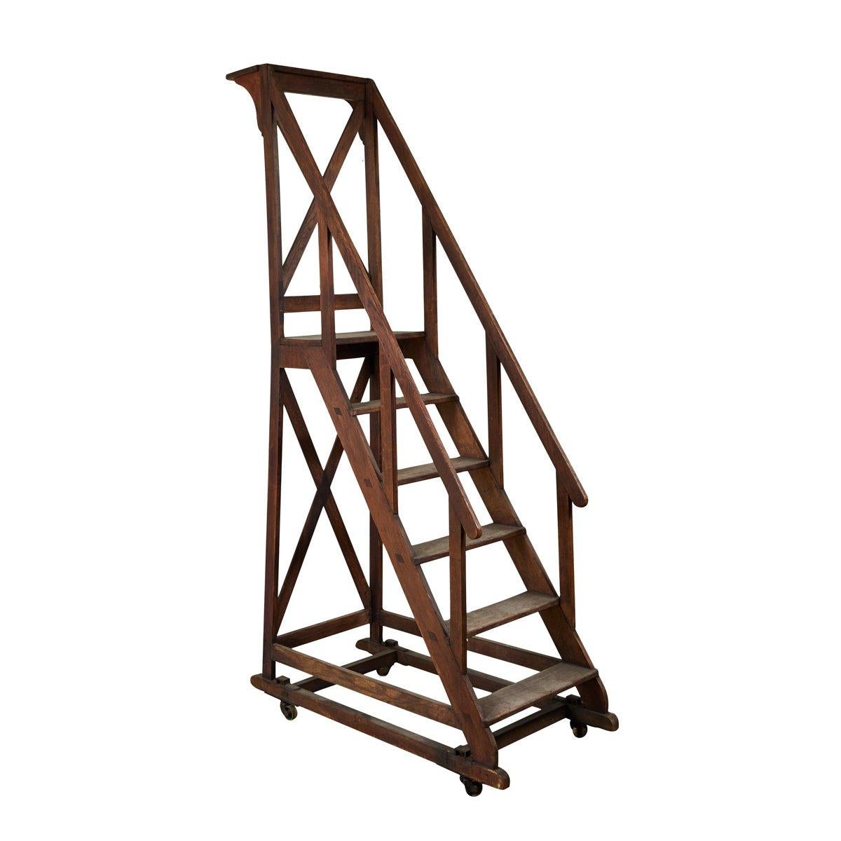 Late 19th-century book ladder from the National Library in Paris.  An extremely special item, the ladder is mounted on casters, and is constructed of a deep, chestnut-colored wood. A handsome architectural piece that would make a simple and refined
