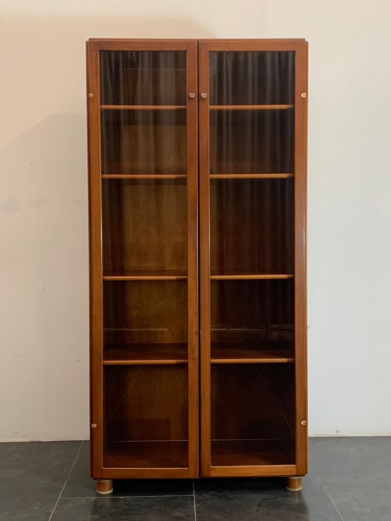 Torcello bookcase, an innovative project in the early 1960s that allowed wooden panels to be joined by a metal profile. Torcello is an example of good cabinet-making and innovation. The wood is walnut. The doors are completely airtight, dustproof