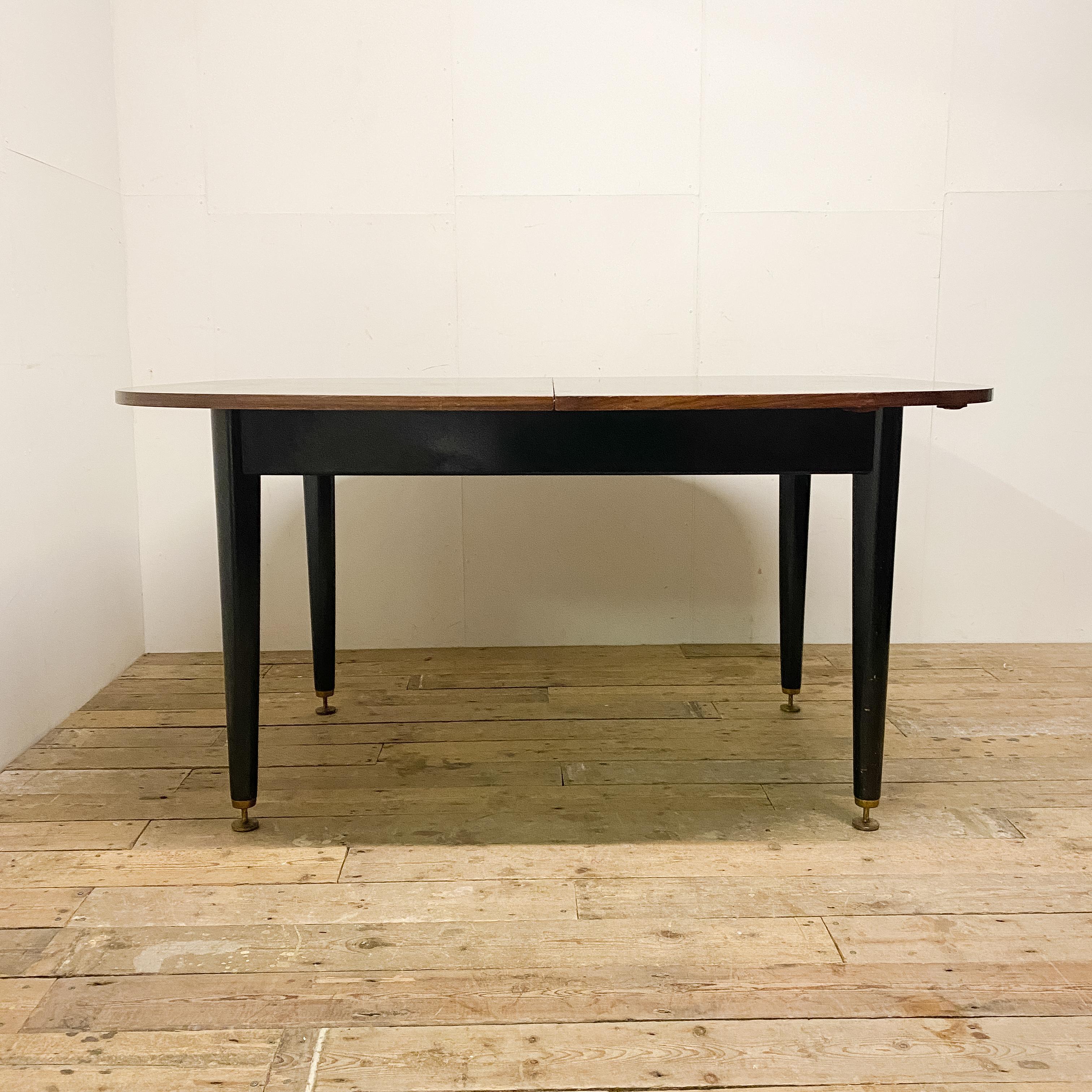 Voici la table de salle à manger Librenza en bois de Tola, conçue par E. Gomme pour G-Plan dans les années 1950. Conçue avec une attention méticuleuse aux détails, cette table de salle à manger est une véritable icône du design du milieu du siècle.