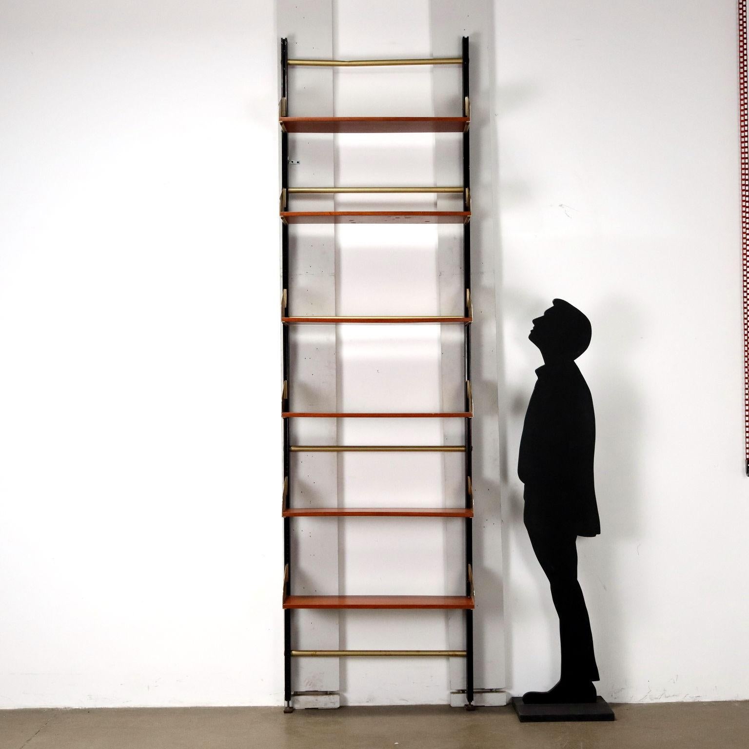 Vintage wall-mounted bookcase with adjustable height shelves made of teak veneer wood with enameled and brass-plated aluminum uprights.