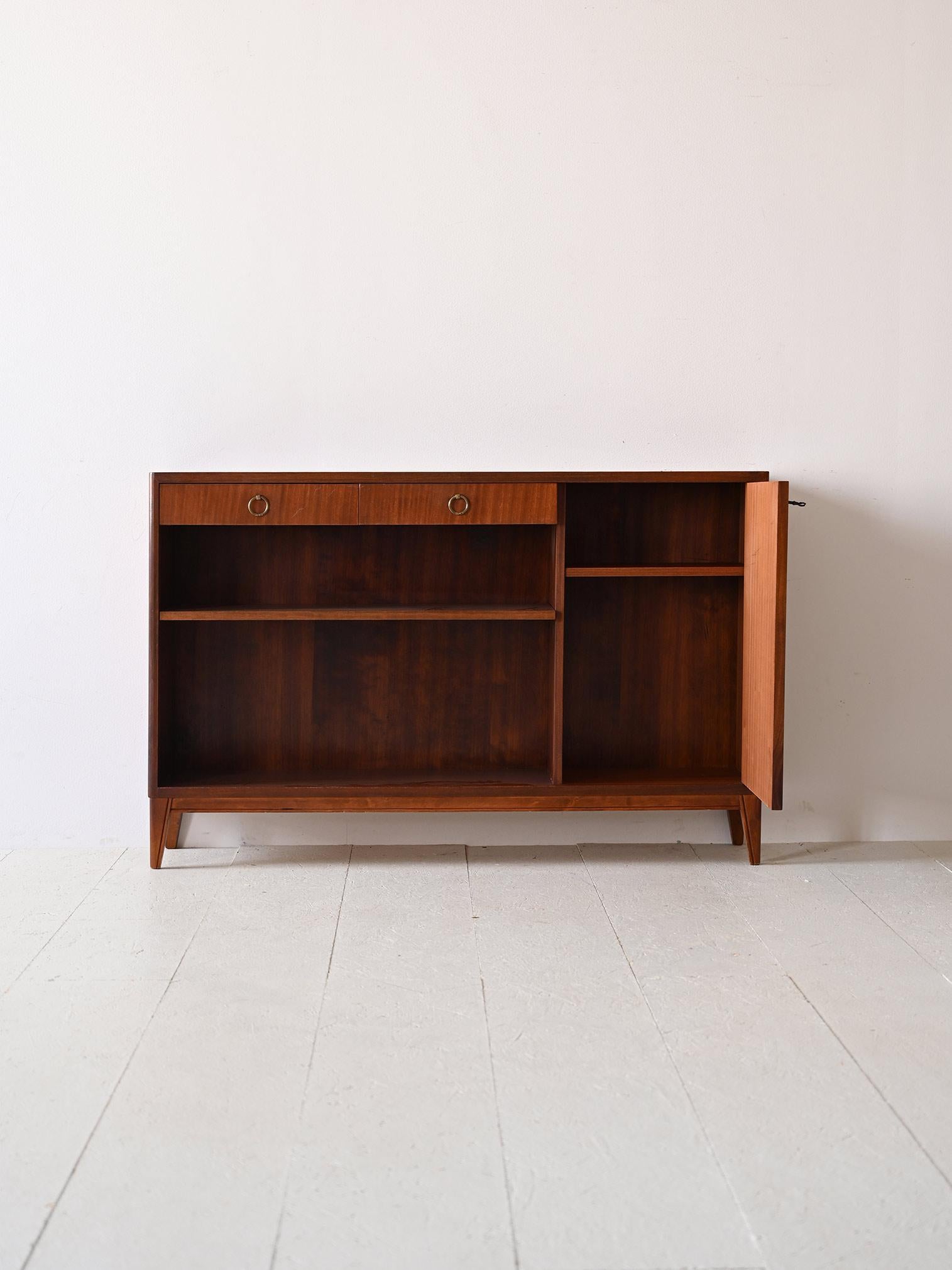 Mahogany sideboard with two drawers and lockable hinged door.

A piece that reflects the sophistication of mid-century design through its modern lines and retro flavor. The drawers provide an elegant solution for storing everyday items, while the