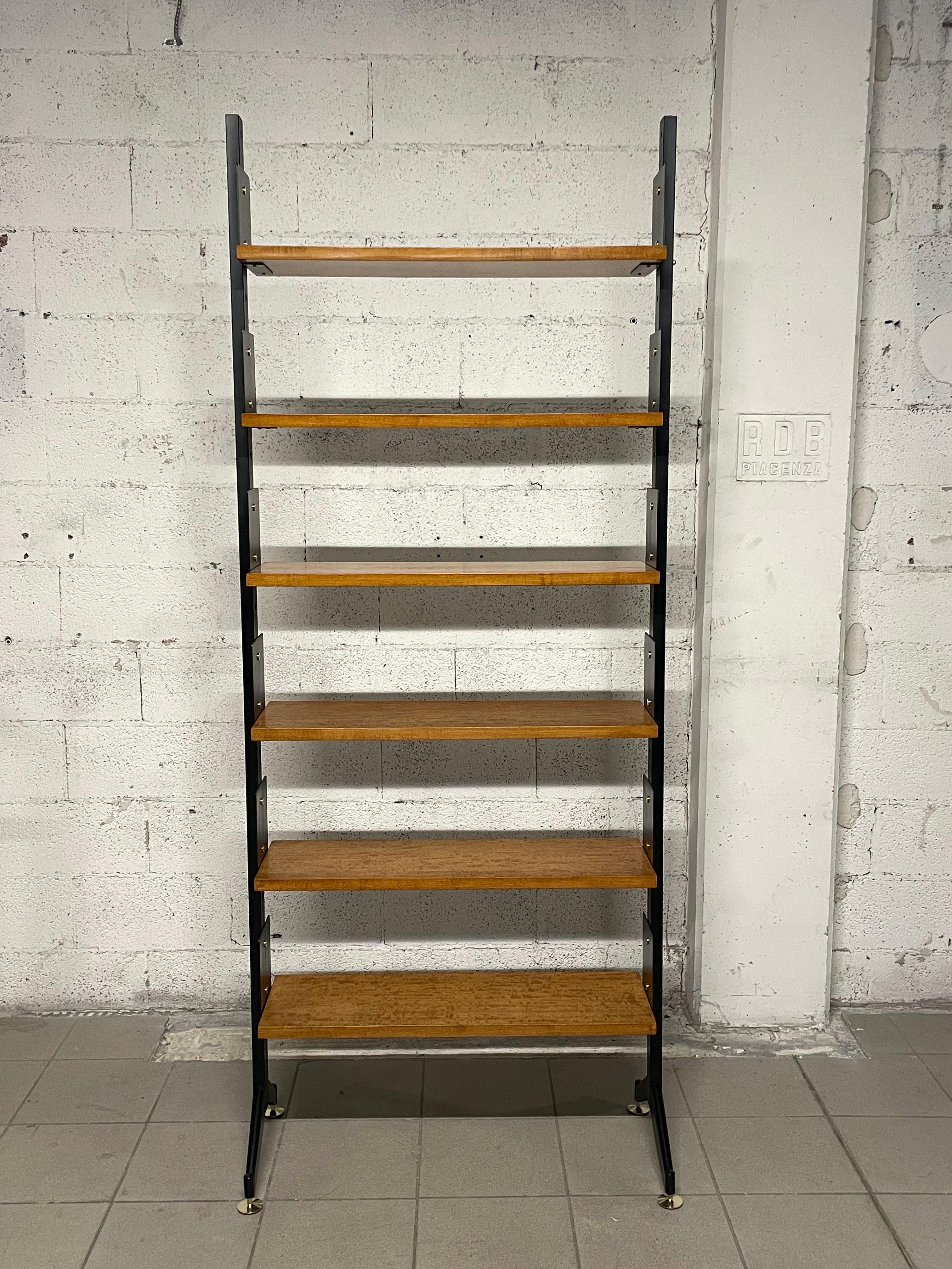 1950s bookcase with black painted iron uprights and brass feet.

The bookcase consists of 6 adjustable-height wooden shelves 25 cm deep.

Fully restored.
