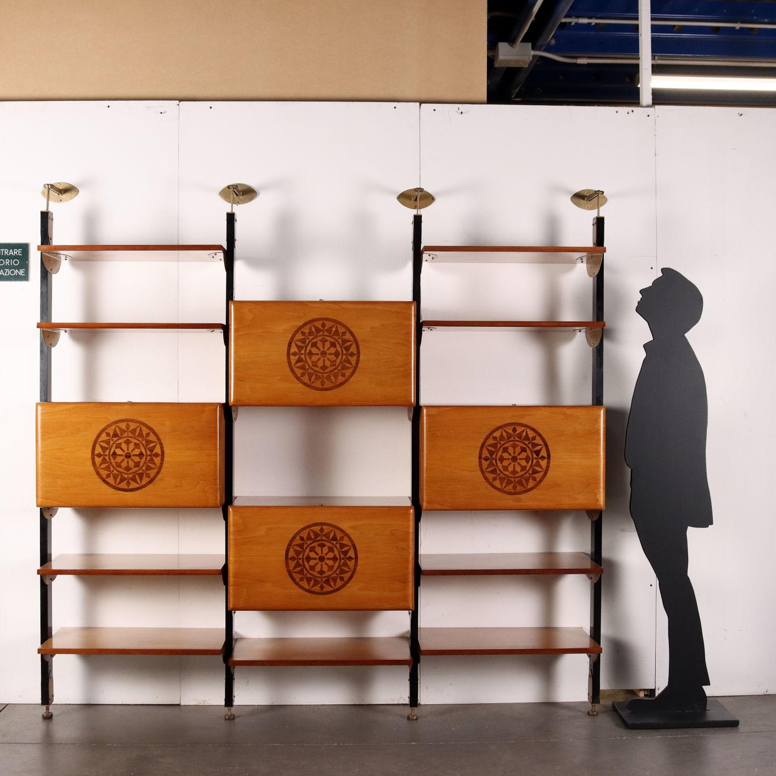 Libreria vintage con sistema di ancoraggio a parete composta da montanti in legno tinto con elementi di fissaggio in metallo smaltato, ripiani e vani contenitori a posizione regolabile con fronte stondato impreziosito da motivo ad intarsio.