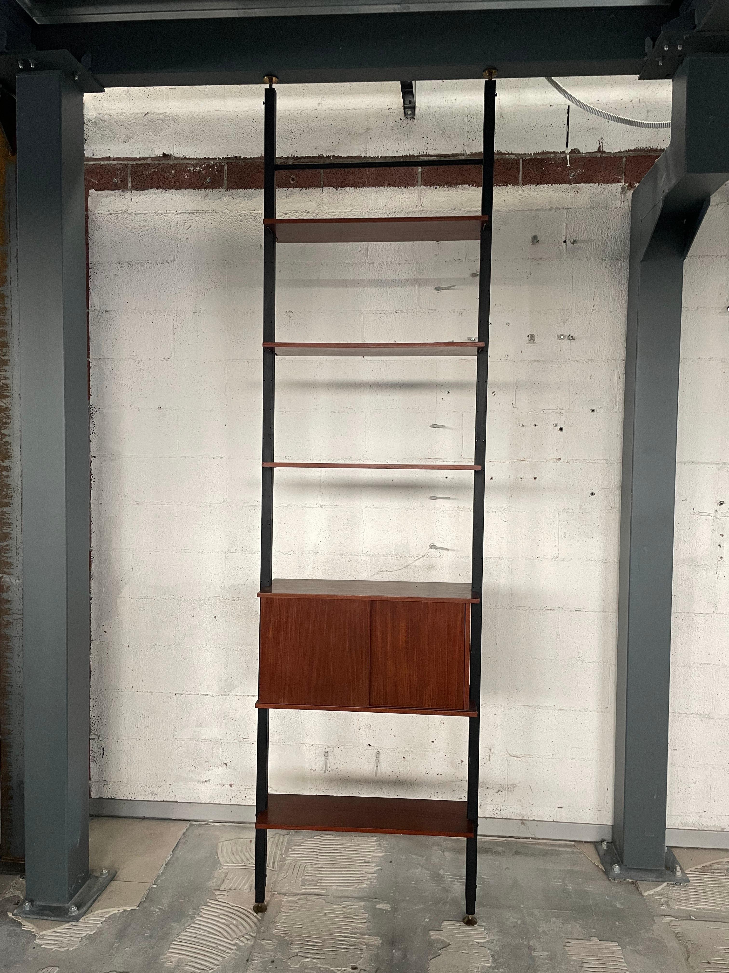 Sky-to-ground bookcase from the 1960s with one bay and consisting of shelves plus a storage compartment.

All elements can be freely placed on the structure consisting of two iron uprights and brass braces.

All wooden parts are made of teak.

Also