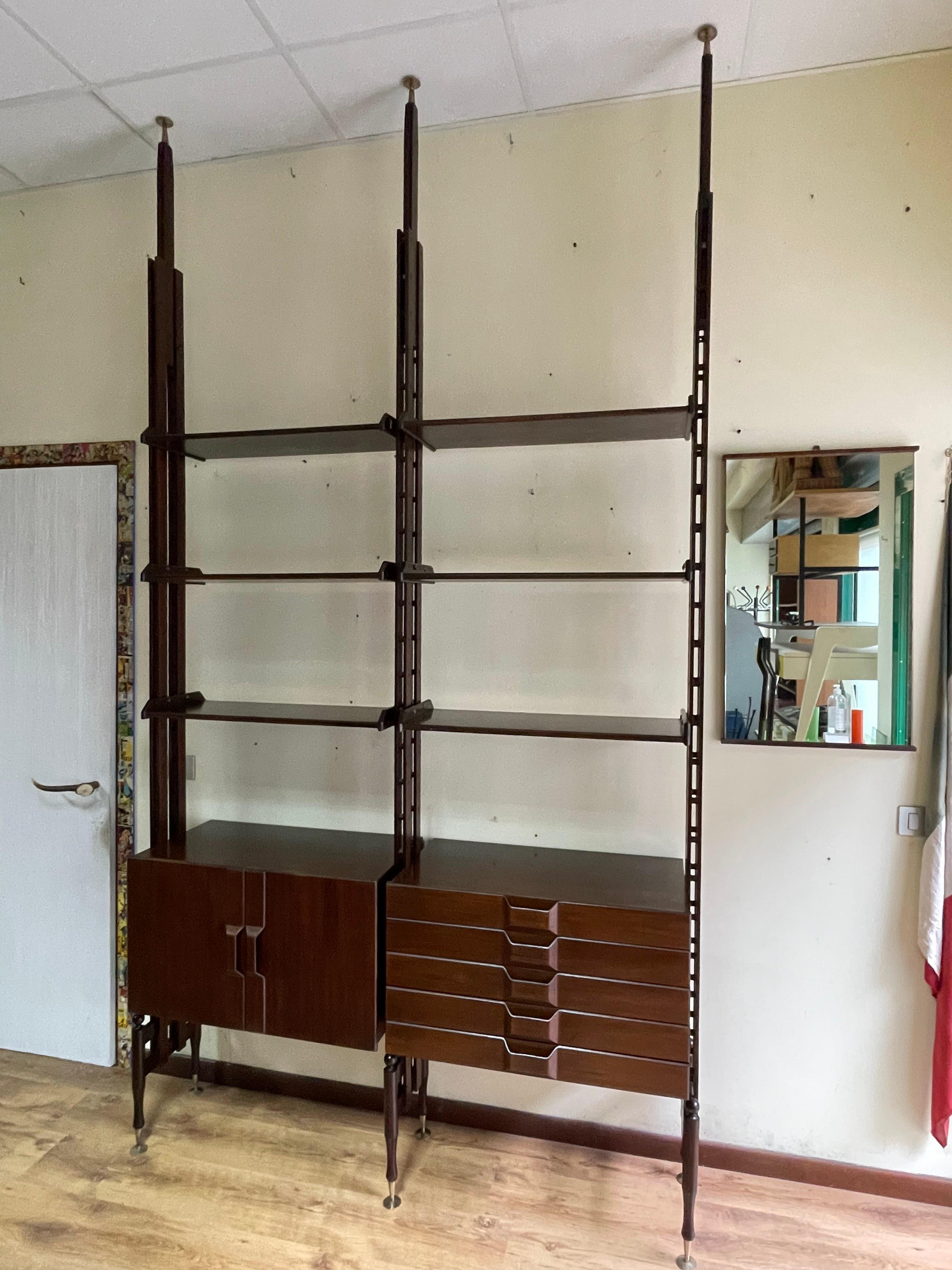Libreria cielo-terra anni '60, a due moduli, in legno di palissandro.

L'altezza della libreria è variabile, da mt. 2,73 a mt. 3,35.
Nelle dimensioni abbiamo riportato solo la misura inferiore.

Puntali e piedini a vite regolabili in