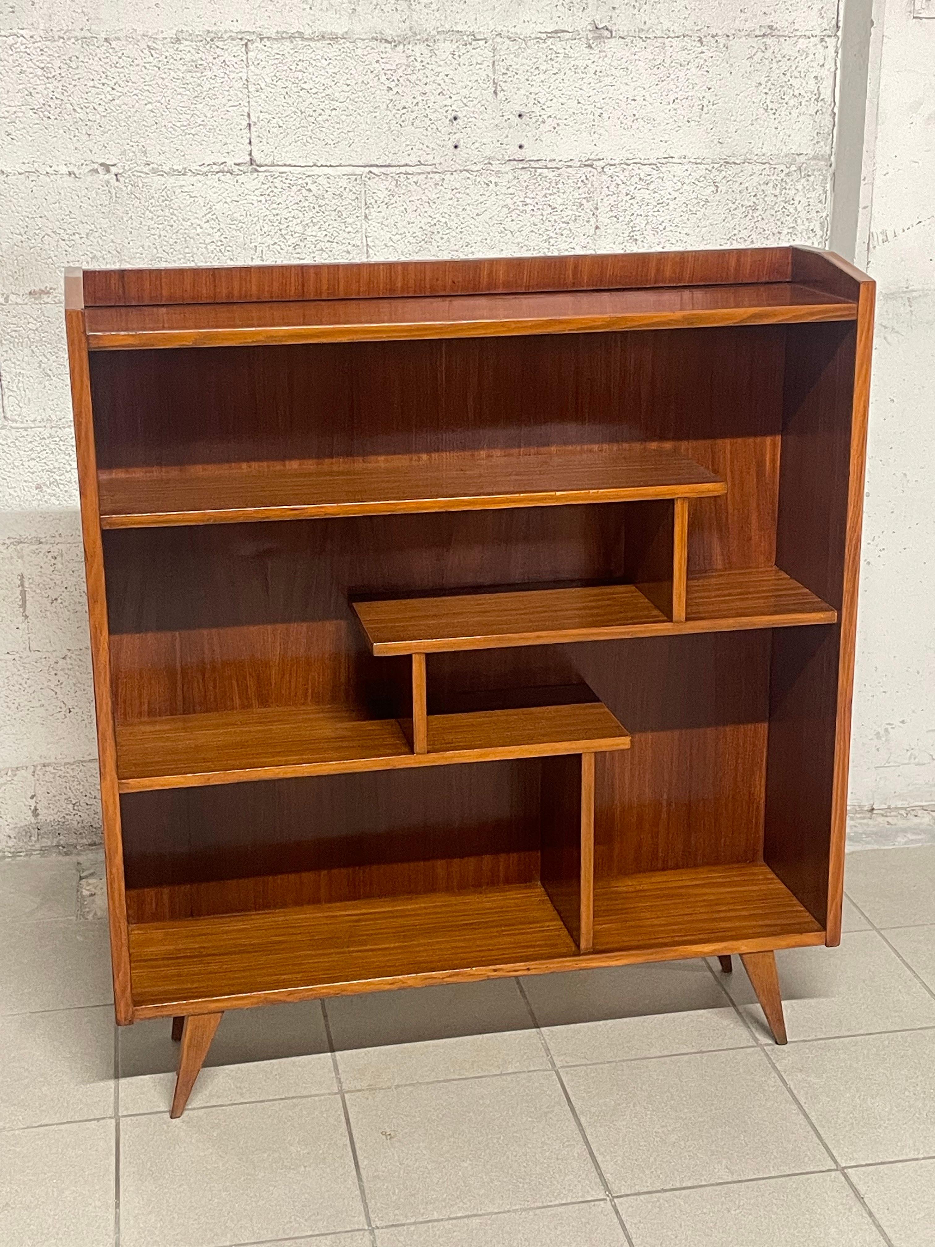Interessante libreria anni '50 dallo stile scandinavo ma di produzione italiana in ottimo legno di mogano.

Piedini a compasso e il motivo degli scaffali interni caratterizzano questa piacevole piccola libreria.

Completamente restaurata.