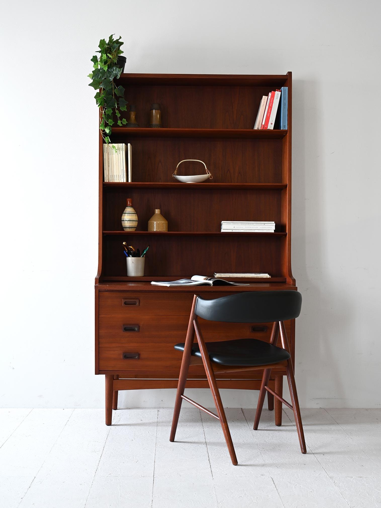 Élégante bibliothèque vintage en teck avec tiroirs et bureau escamotable. Un design scandinave essentiel agrémenté de poignées sculptées.

Cette bibliothèque danoise des années 1950 est en teck. Les lignes épurées et légères reflètent l'esthétique