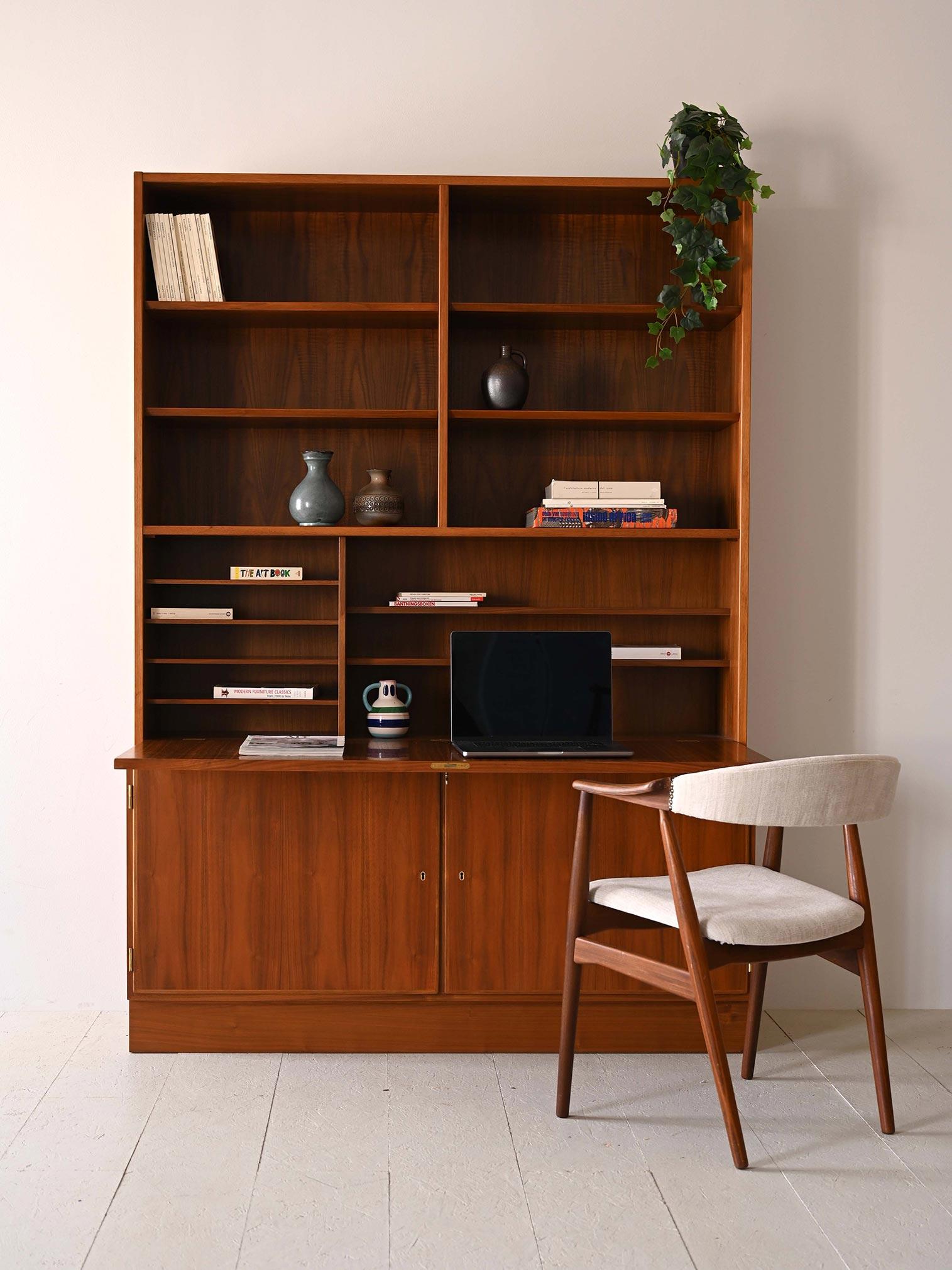 Vintage 1960s cabinet with shelving and storage compartment.

This Scandinavian bookcase with drop-down door is a perfect example of Scandinavian design that aims to combine aesthetics and functionality. The top of the cabinet features open shelving