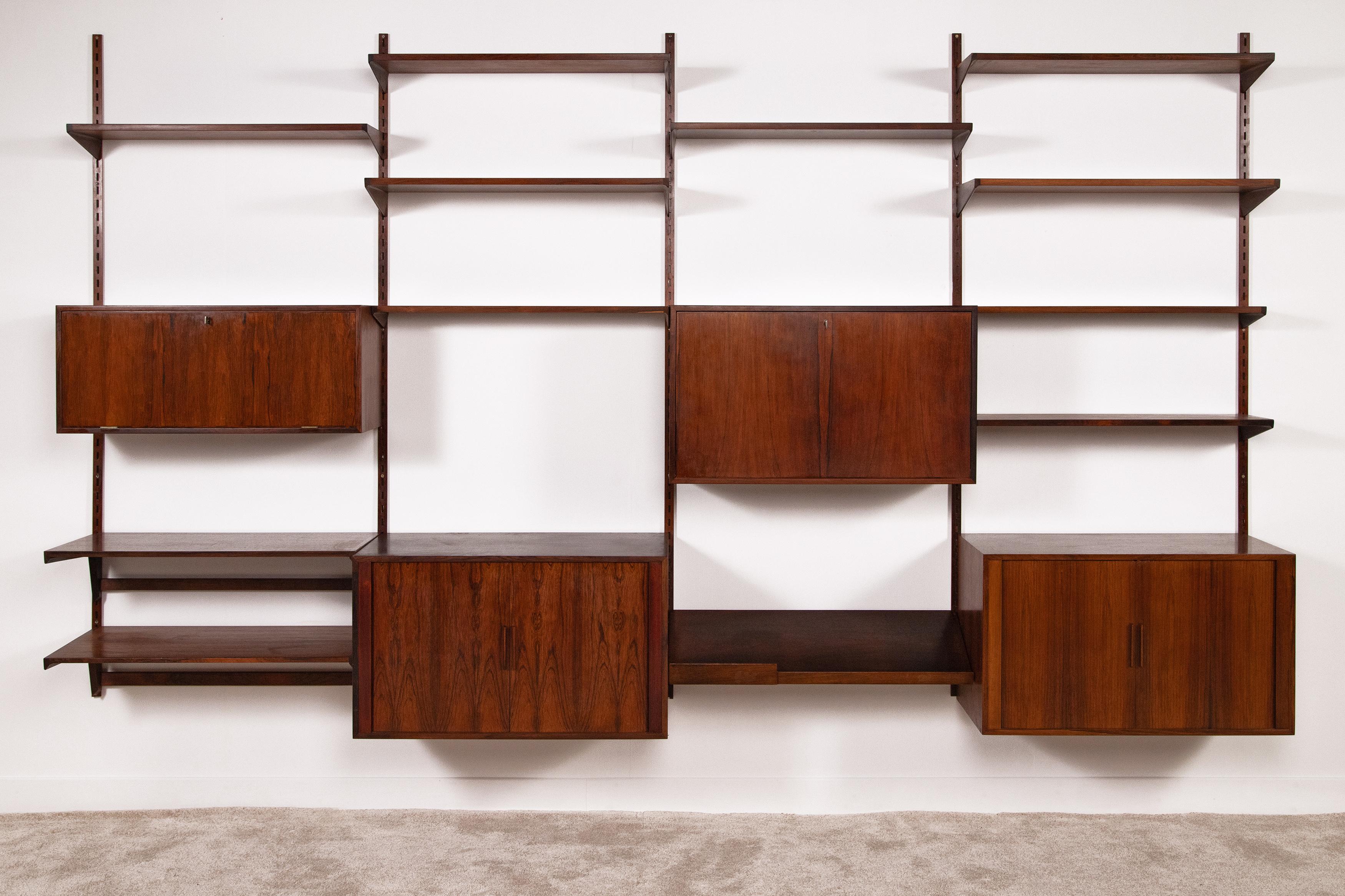 1960s wall bookcase mod. FM Reolsystem by Kai Kristiansen for FM Møbler currently out of production. Veneered in fine rosewood with wood-effect aluminum uprights, it consists of 4 modules (each 86 cm wide). It features 4 closed compartments (2 that