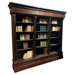 Solid walnut bookcase, carved with columns, Italy