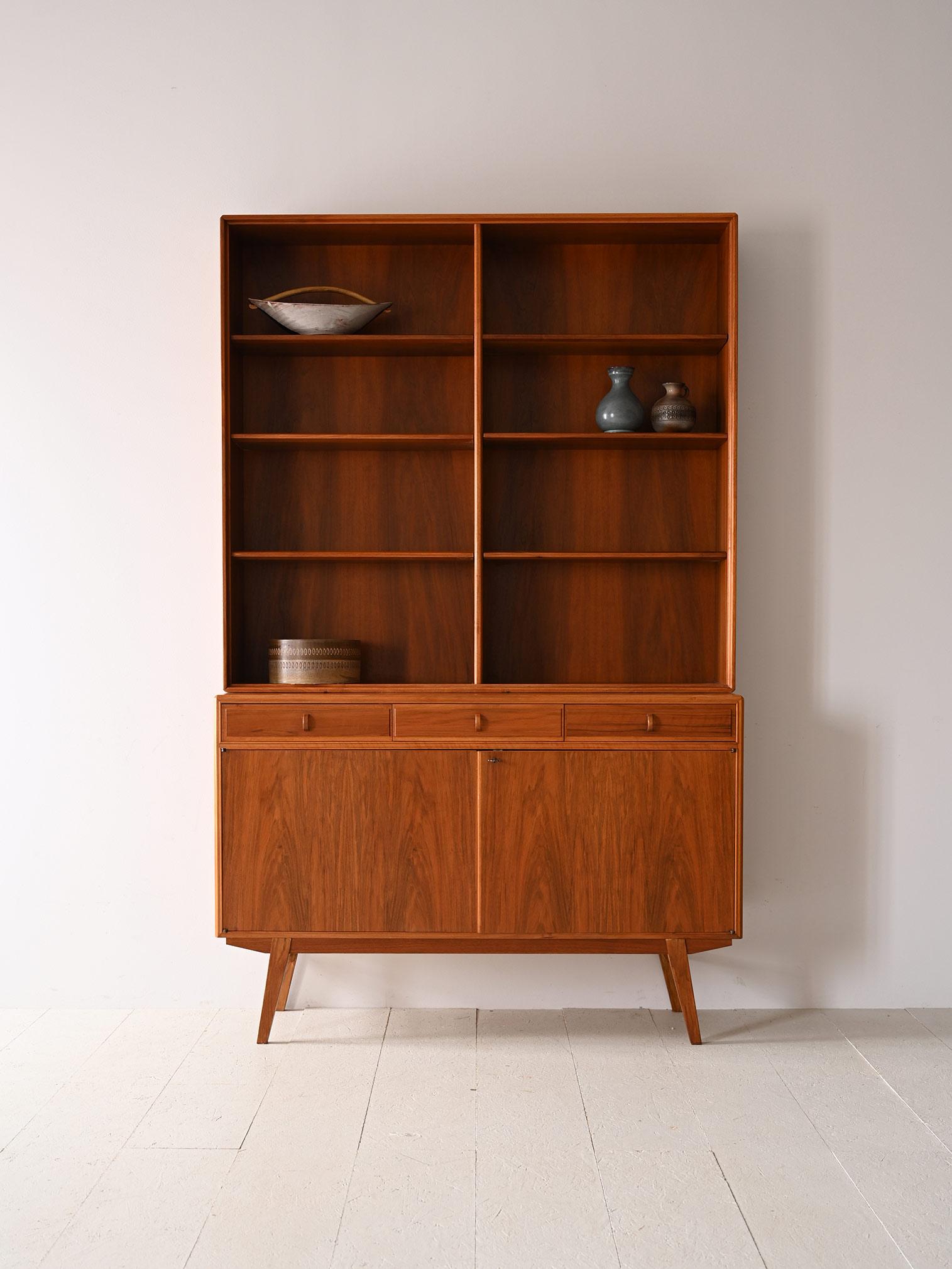 This Scandinavian bookcase from the 1960s is a masterpiece of design and functionality. With top shelves for displaying books and art objects, it is complemented by drawers and doors that offer elegant and discreet storage solutions. The teak