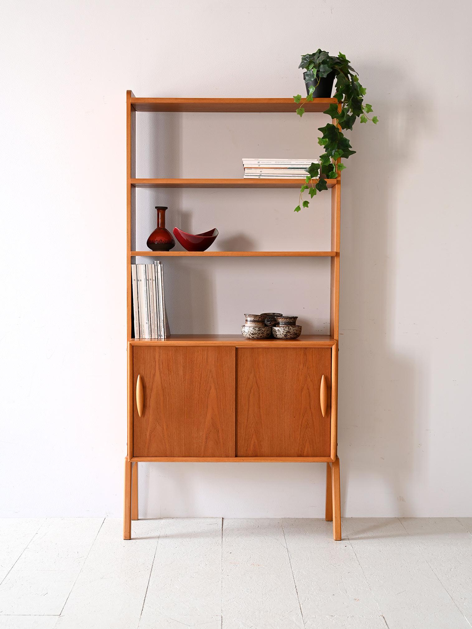With its slender frame and sliding doors, this Swedish bookcase is a classic example of Scandinavian design from the 1950s and 1960s. Its shelves provide ample space for books and decorative items, while sliding doors conceal what you prefer to keep