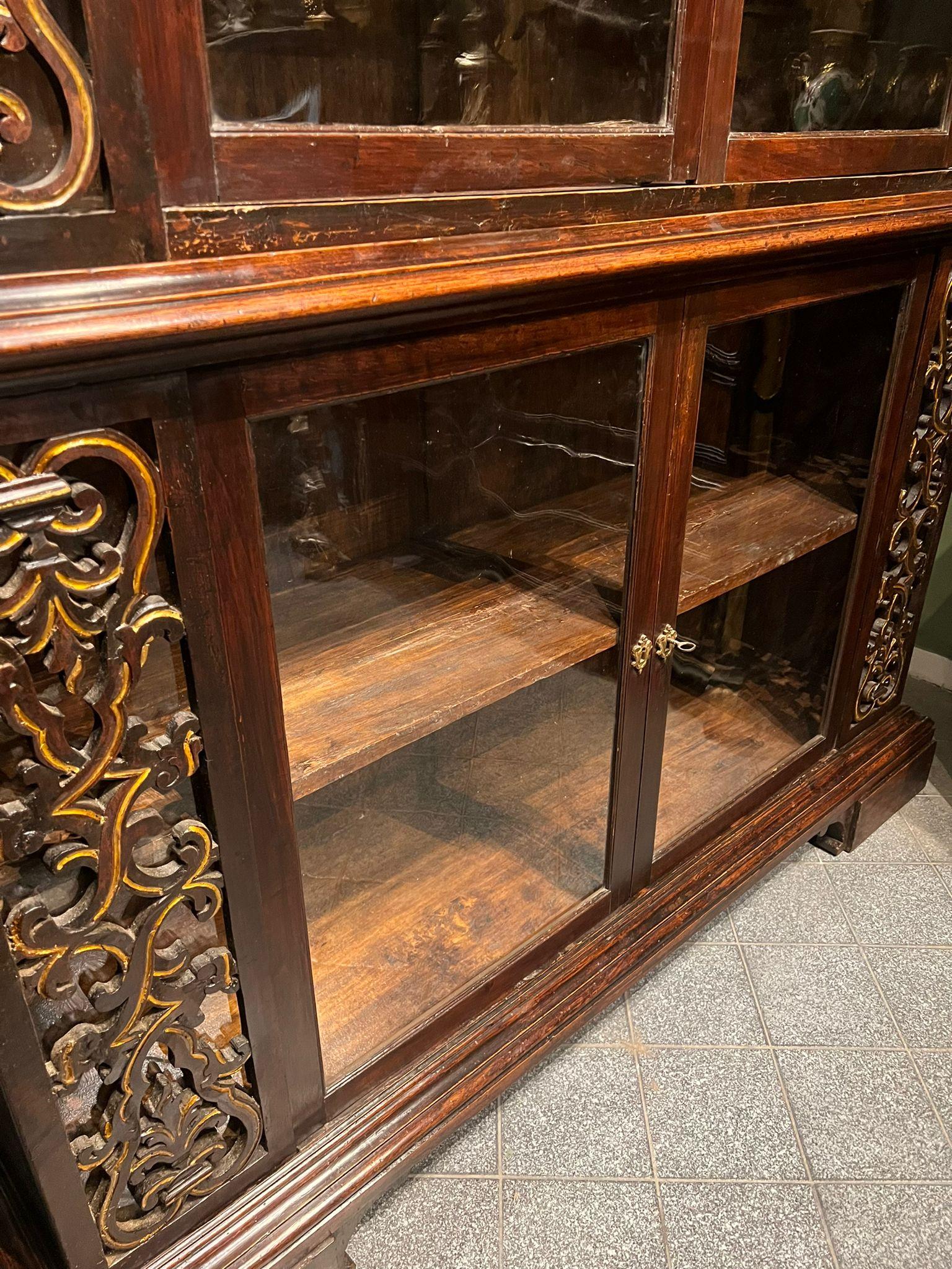 Splendid bookcase dating from the late 18th or early 19th century, featuring a rich artistic style typical of church and convent furnishings. The cabinet shows special attention to the carved and gilded details that adorn the side pillars and the