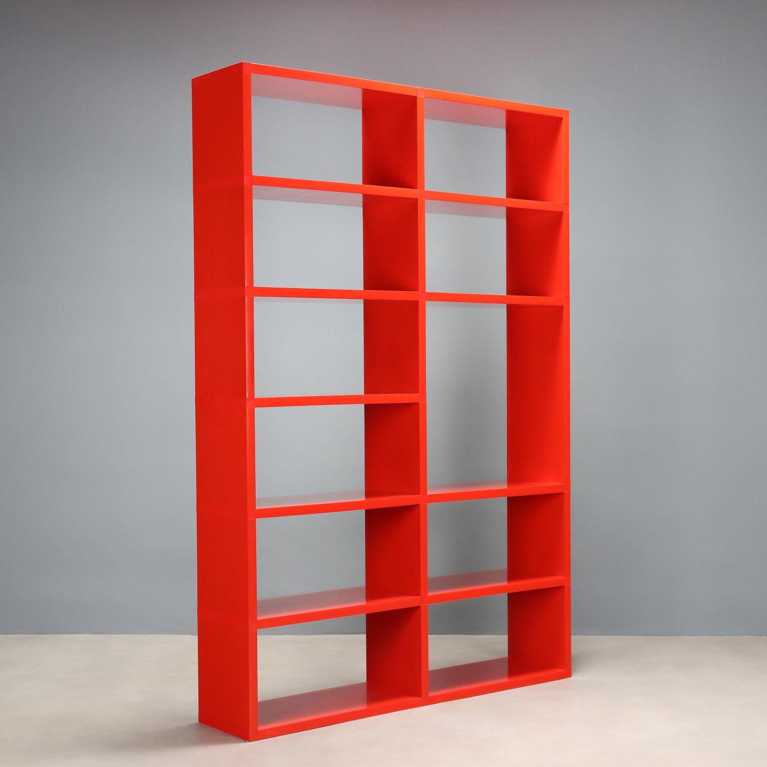 Libreria modulare in materiale plastico rosso con elementi a posizione regolabile. Presente il marchio della manifattura.