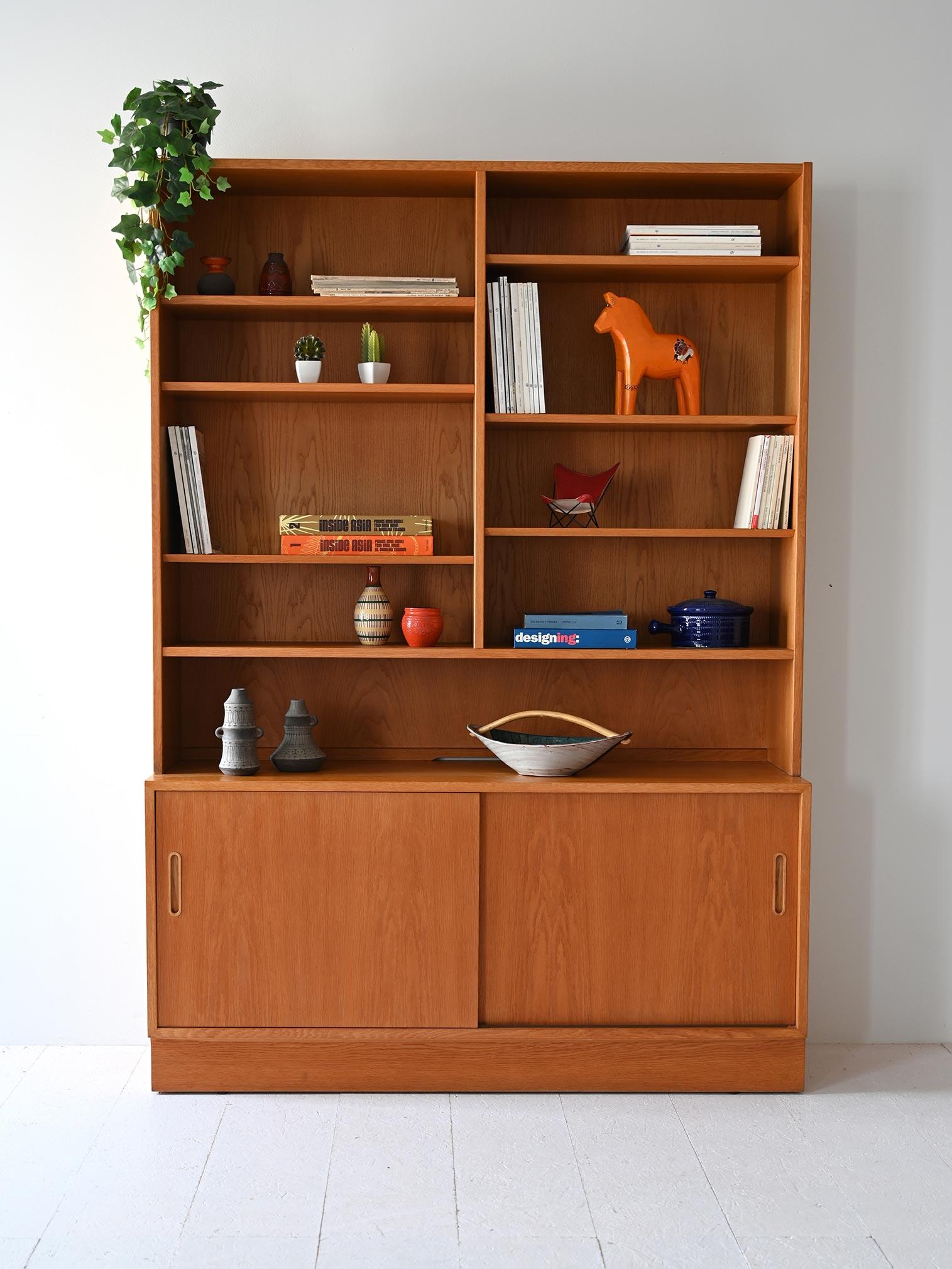 Modularer Schrank mit Sideboard und offenen Regalen. Die Struktur ist aus Teakholz, original 1960er Jahre.

Im unteren Teil befindet sich ein Fach mit zwei praktischen Schiebetüren, während die zahlreichen offenen Regale idealen Platz für Bücher,