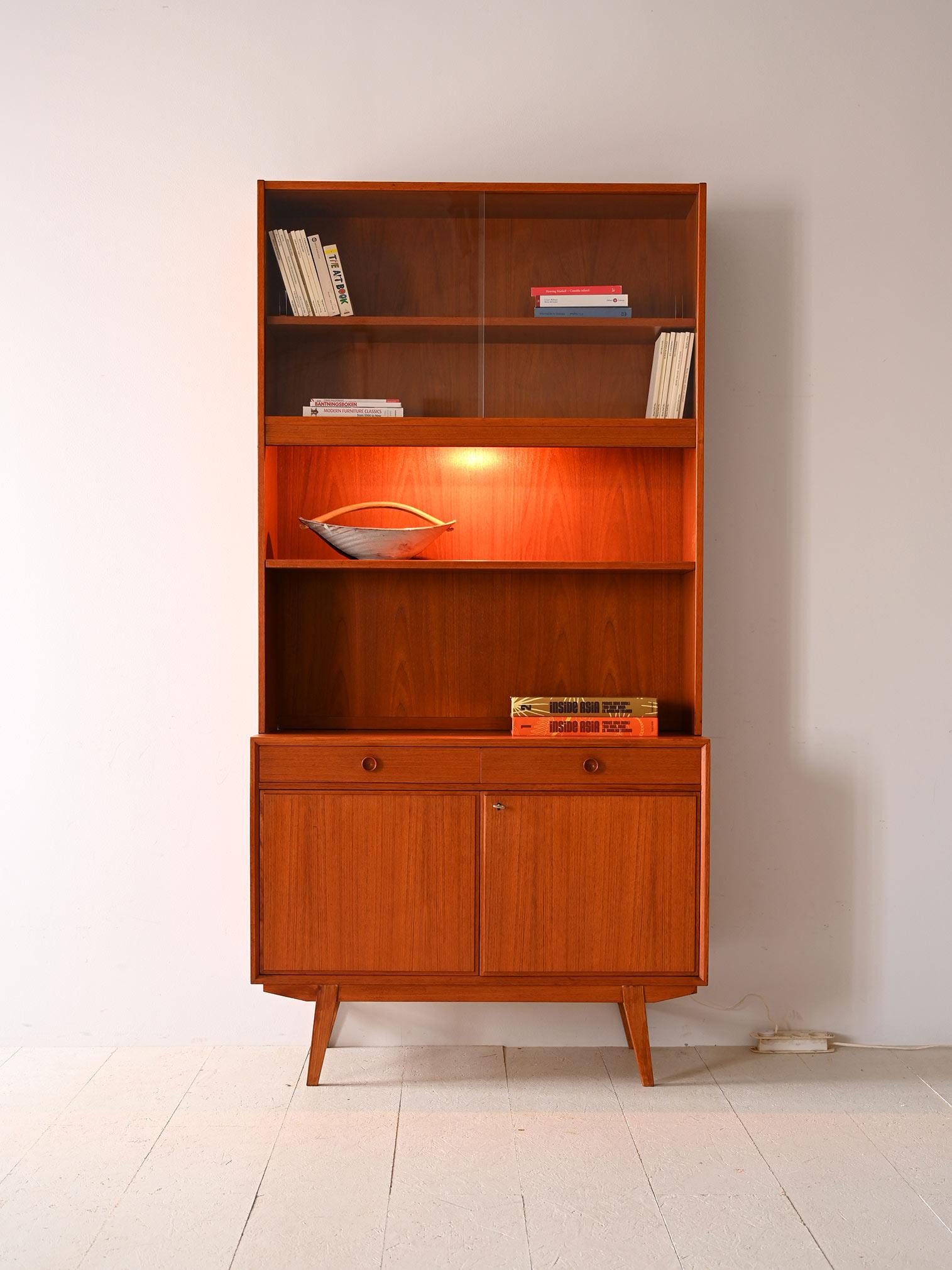 Libreria a giorno vintage con vano contenitore.

Questa libreria svedese rispecchia nel gusto e nelle linee la maestria del design scandinavo anni '60.
Costituita da una vetrinetta, da scaffalature a giorno e da un vano chiuso da ante a battente