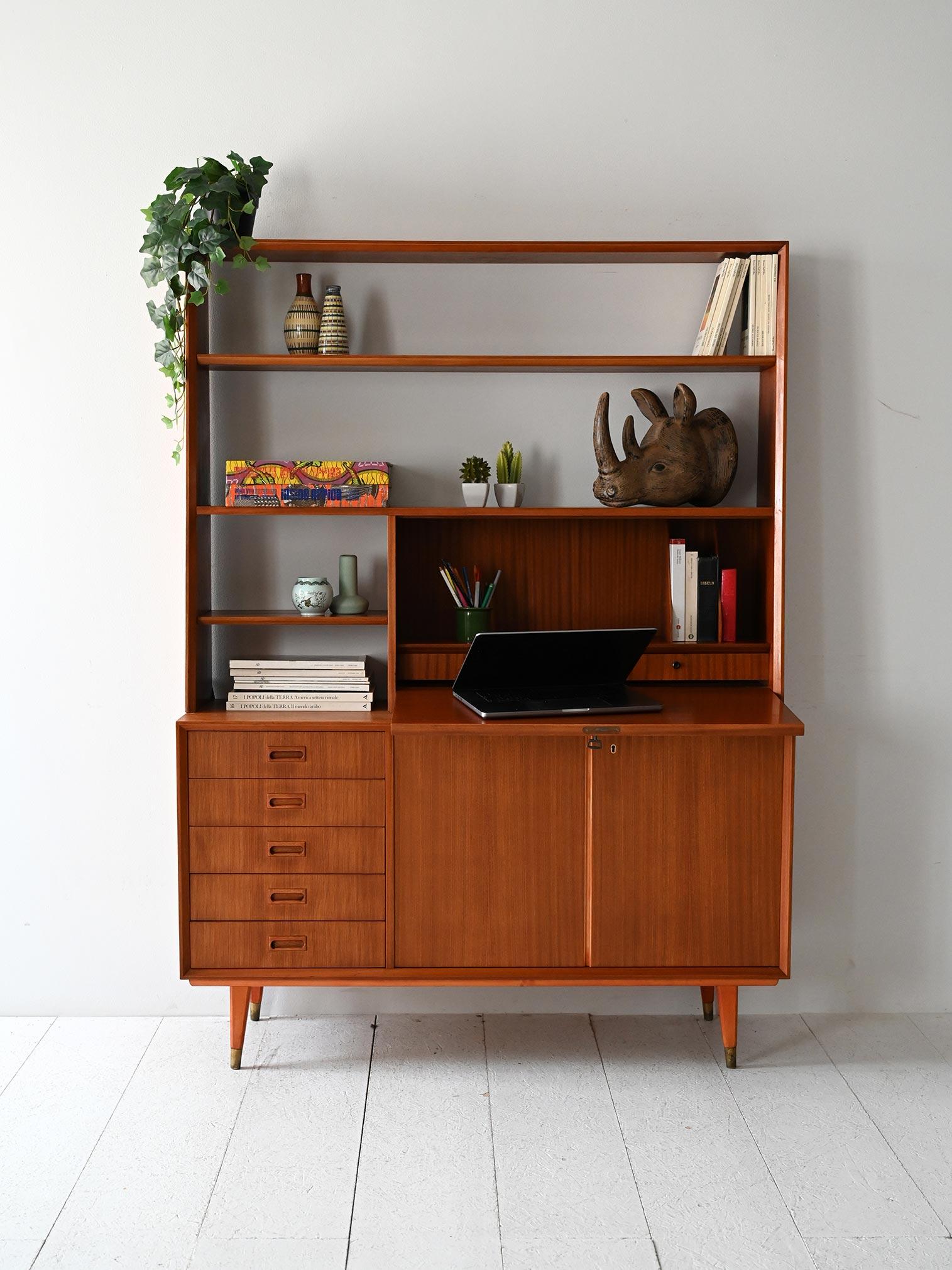 Libreria anni ’60 in mogano con base a sideboard, ribalta con vano porta documenti e scaffali a vista.

Mobile libreria scandinavo anni ’60 in mogano, con parte inferiore a sideboard integrato: cinque cassetti, vano contenitore con ante a battente e