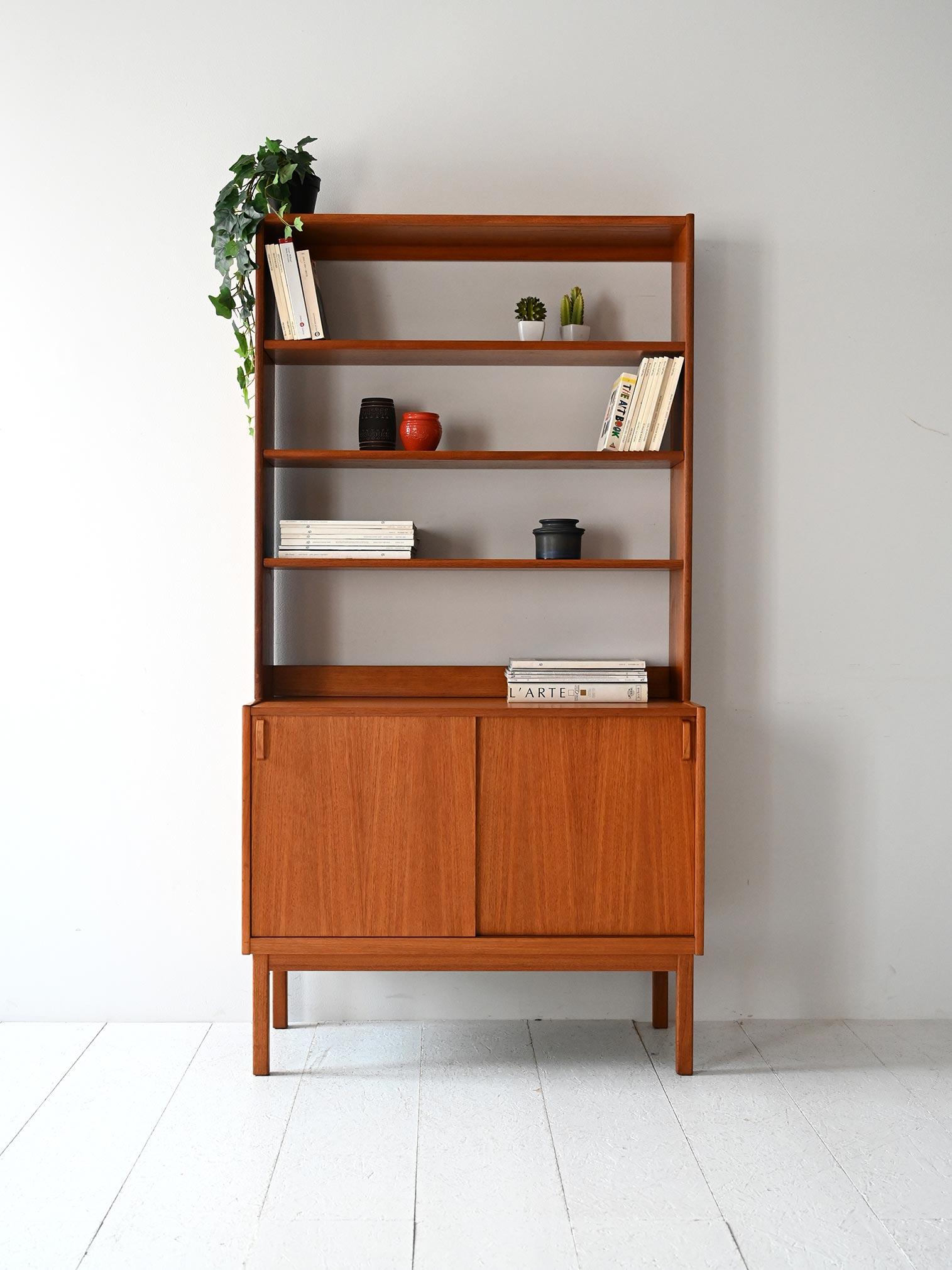 Bibliothèque en teck avec étagères ouvertes, compartiment de rangement avec portes coulissantes, poignées incurvées en teck et marquage d'origine.

Bibliothèque scandinave des années 1960 conçue par B. Fridhagen pour Bodafors, en teck avec une
