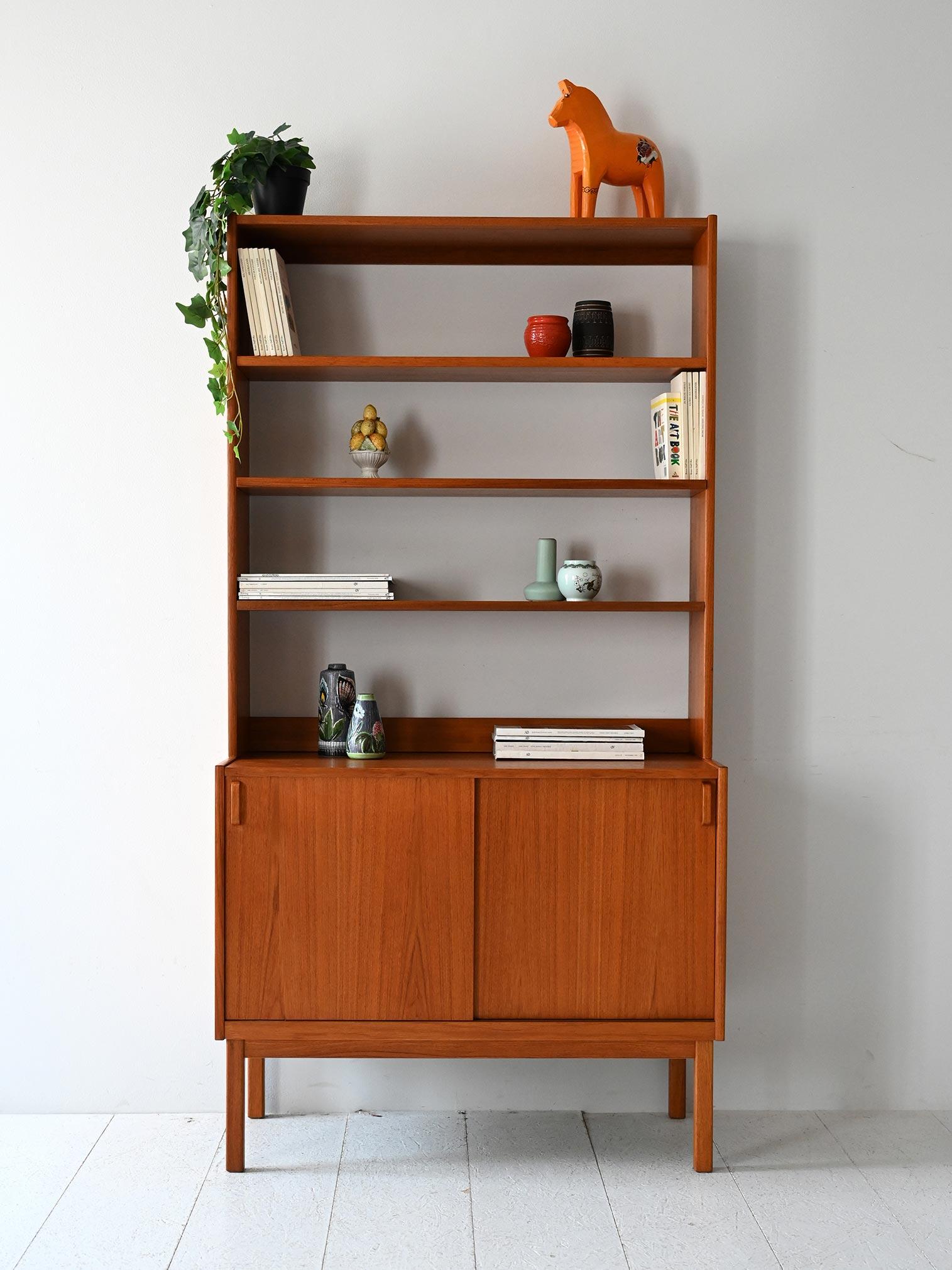 Bibliothèque en teck avec étagères ouvertes, compartiment de rangement avec portes coulissantes, poignées incurvées en teck et marquage d'origine.

Bibliothèque scandinave des années 1960 conçue par B. Fridhagen pour Bodafors, en teck avec une