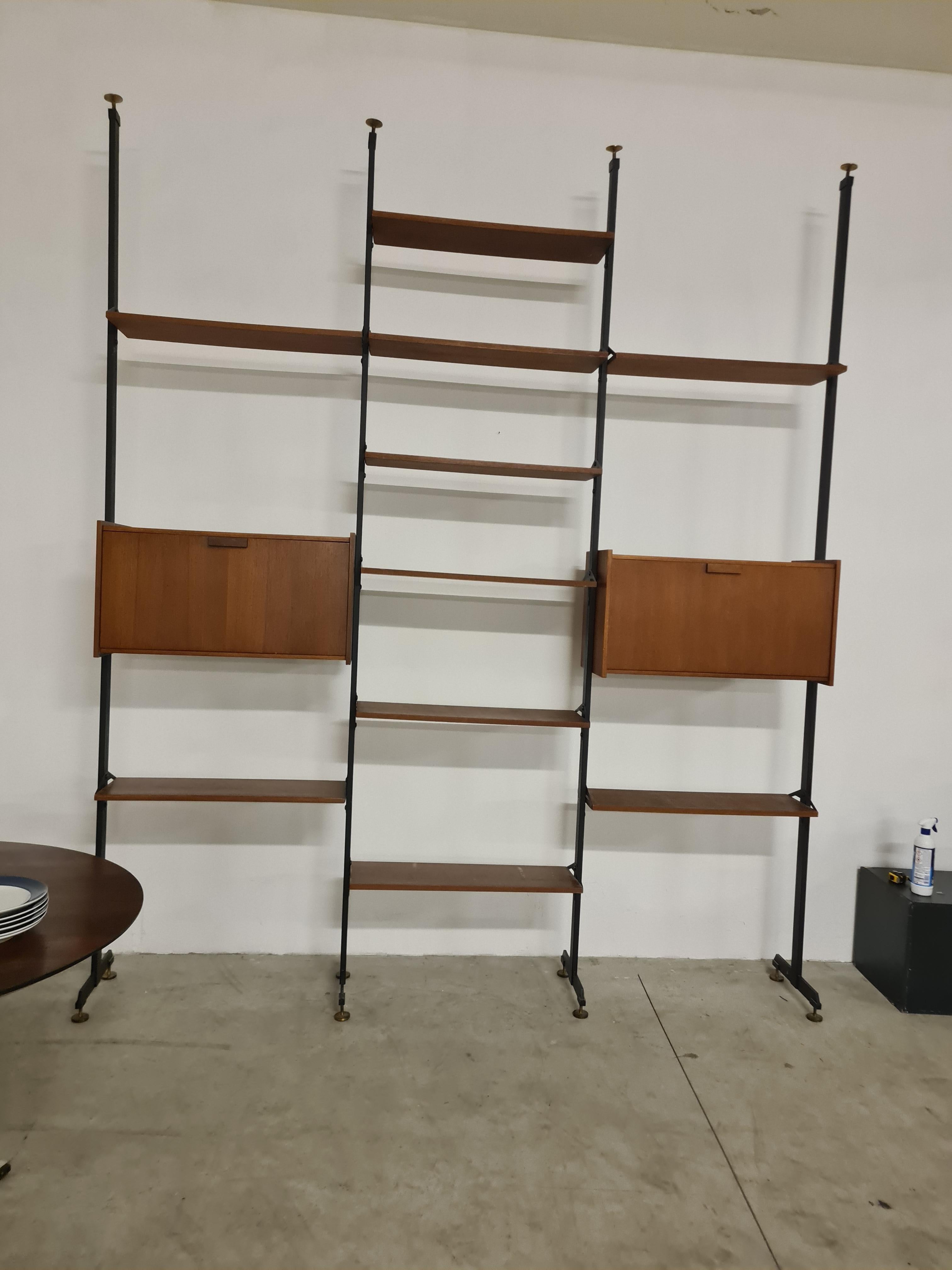 Libreria terra cielo anni 50 - 60 stile svedese.

Scaffalatura a tre campate con elementi in legno impiallacciato a posizione regolabile.

Montanti in metallo verniciato con piedi e puntali in ottone.

Ideale a parete o per dividere uno spazio.

Può