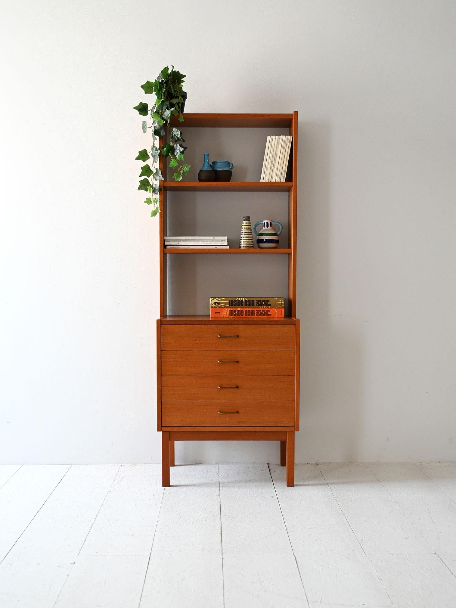 Libreria anni ’60 in teak con tre ripiani regolabili, quattro cassetti e gambe squadrate.

Libreria scandinava vintage anni ’60 in teak, composta da una parte inferiore con quattro cassetti e una parte superiore con scaffalatura aperta. I ripiani