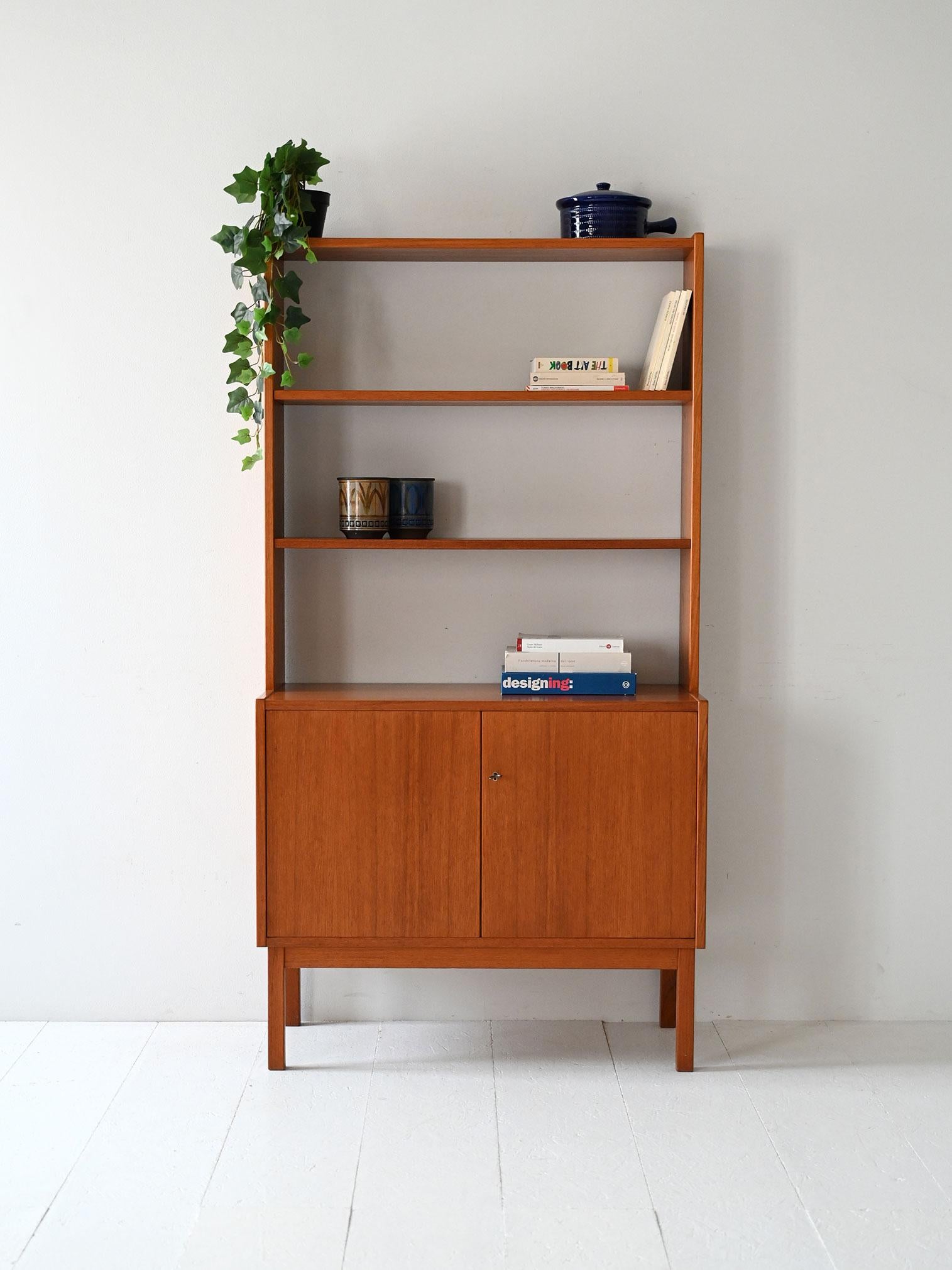 Bibliothèque en teck des années 1950/60 avec portes battantes, étagères réglables et clé d'origine.

Bibliothèque vintage en teck scandinave des années 1950/60. La partie supérieure comporte des étagères visibles réglables, tandis que la base