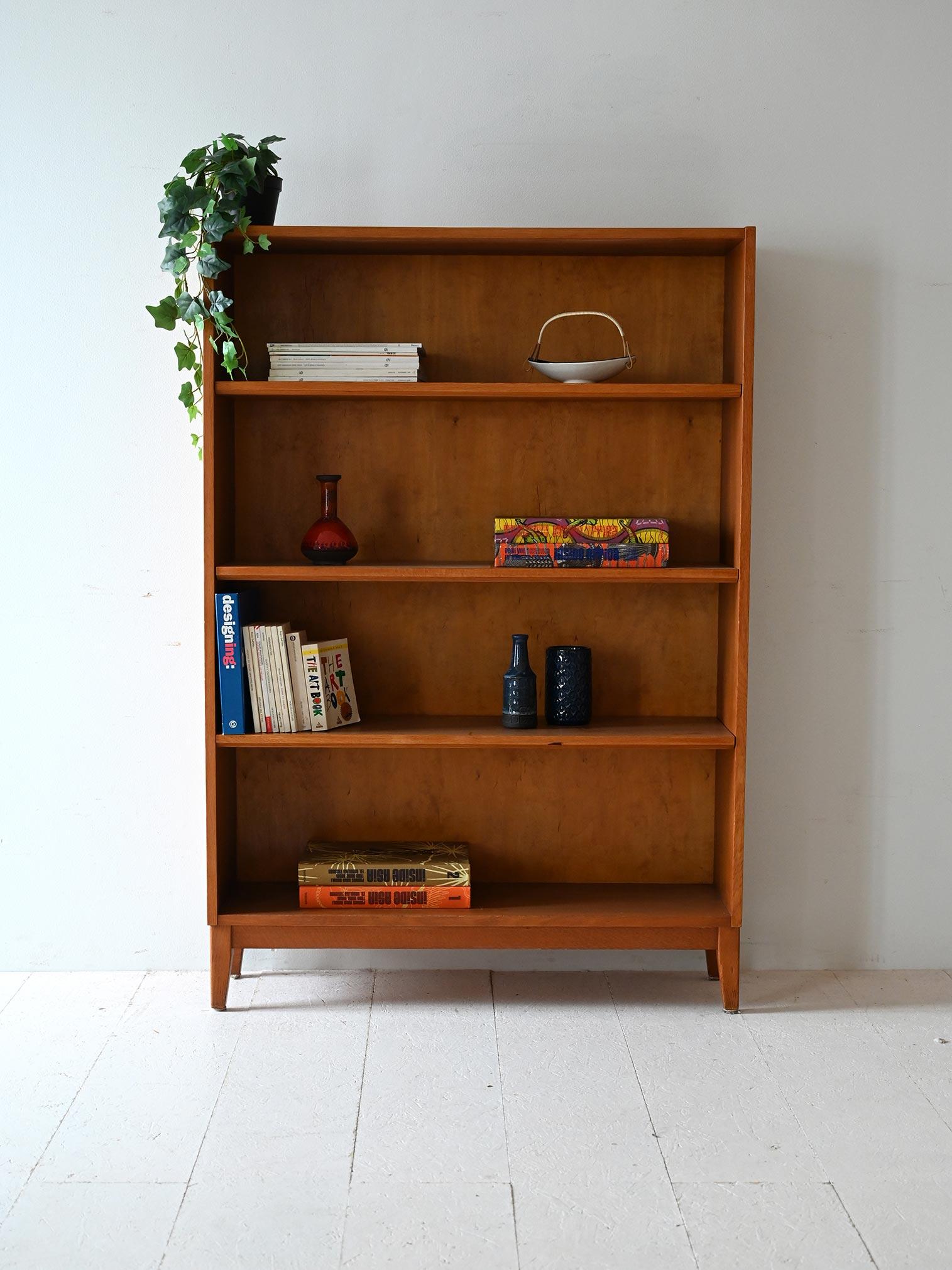 Light oak 1950s/60s bookcase with four shelves and shaped feet, with an understated and functional style.

Linear light oak frame bookcase with contrasting back, typical of Scandinavian design between the 1950s and 1960s. The four shelves offer good