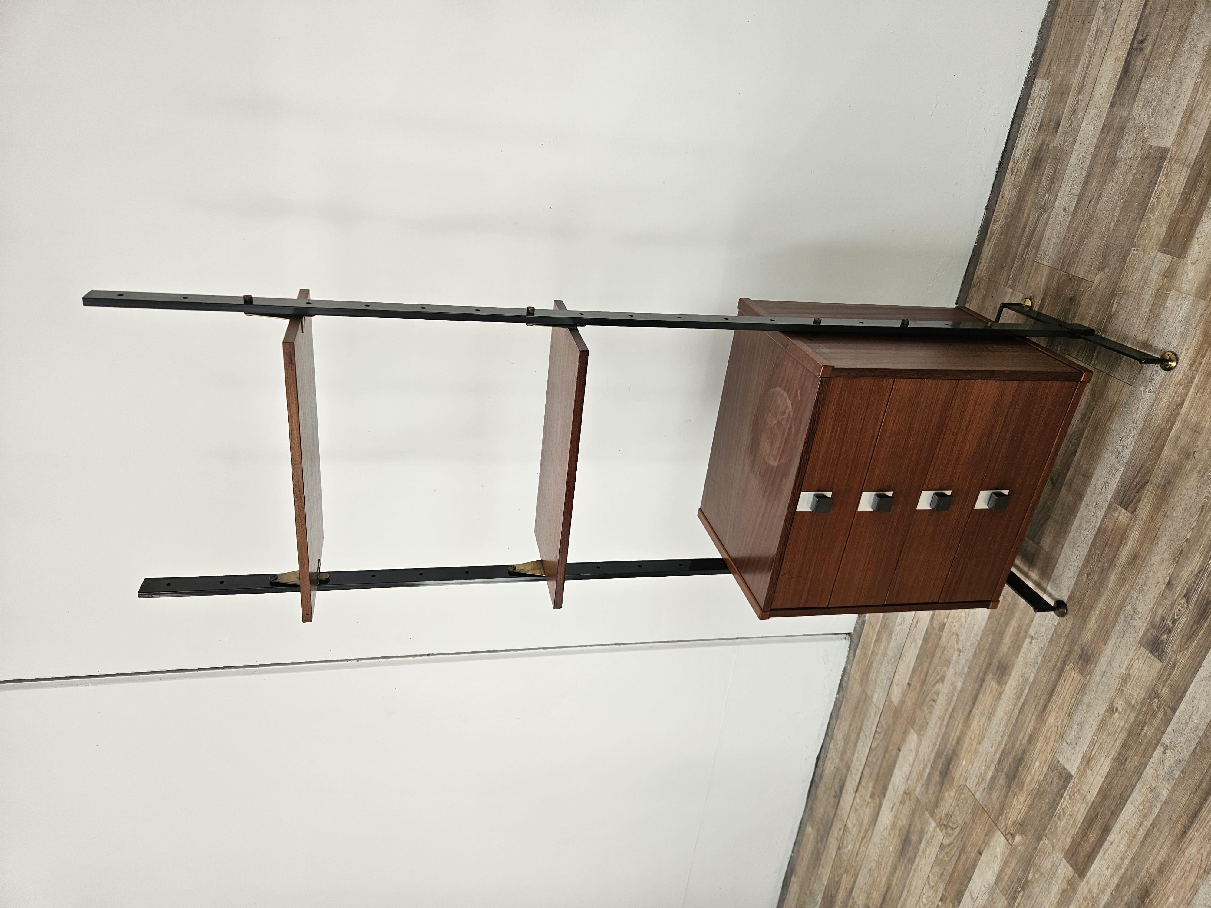 Moderna librería o aparador de los años 70 de Dal Vera SPA con madera de teca y estructura de hierro.

Destacan las patas de latón regulables en altura, ideales para adaptarse a cualquier tipo de suelo.

El armario tiene dos estantes y cuatro