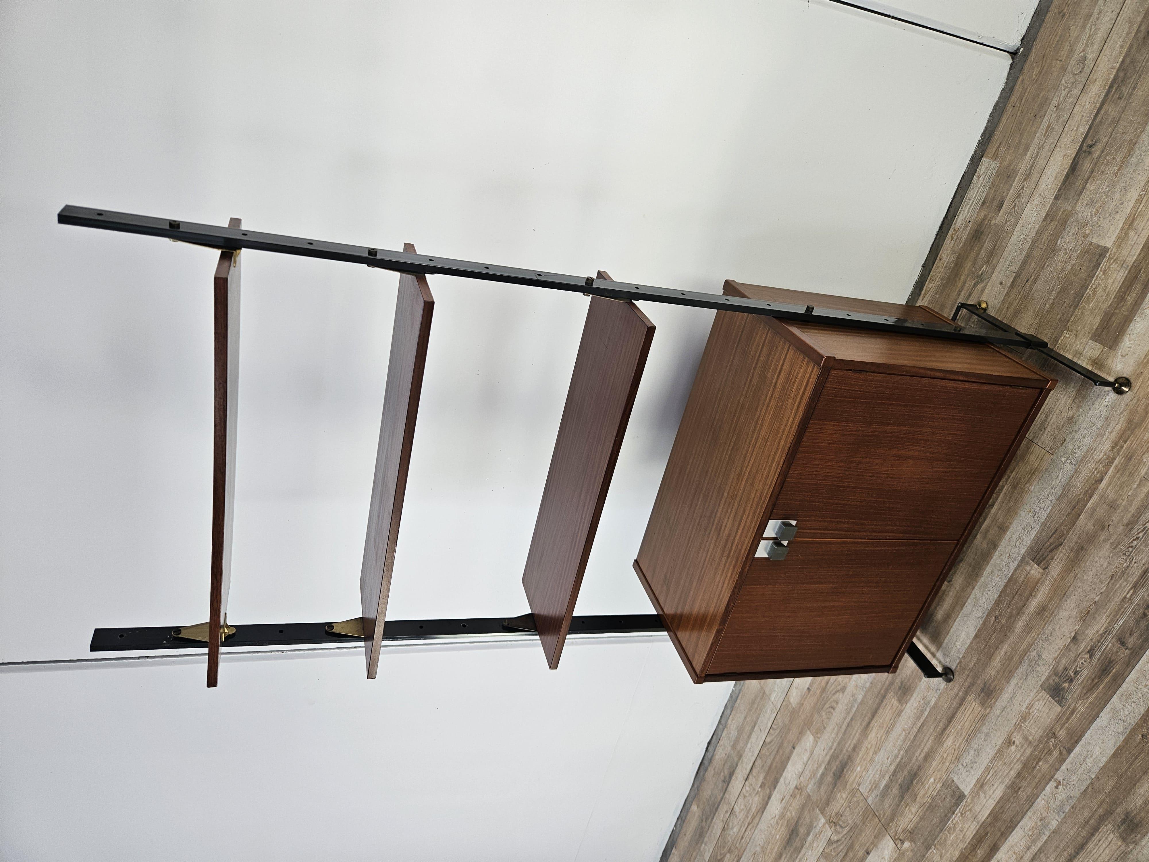 Librería o aparador moderno de los años 70 de Dal Vera SPA, modelo 80251, con estructura de madera de teca y hierro.

Destacan las patas de latón regulables en altura, ideales para adaptarse a cualquier tipo de suelo.

El armario tiene tres estantes
