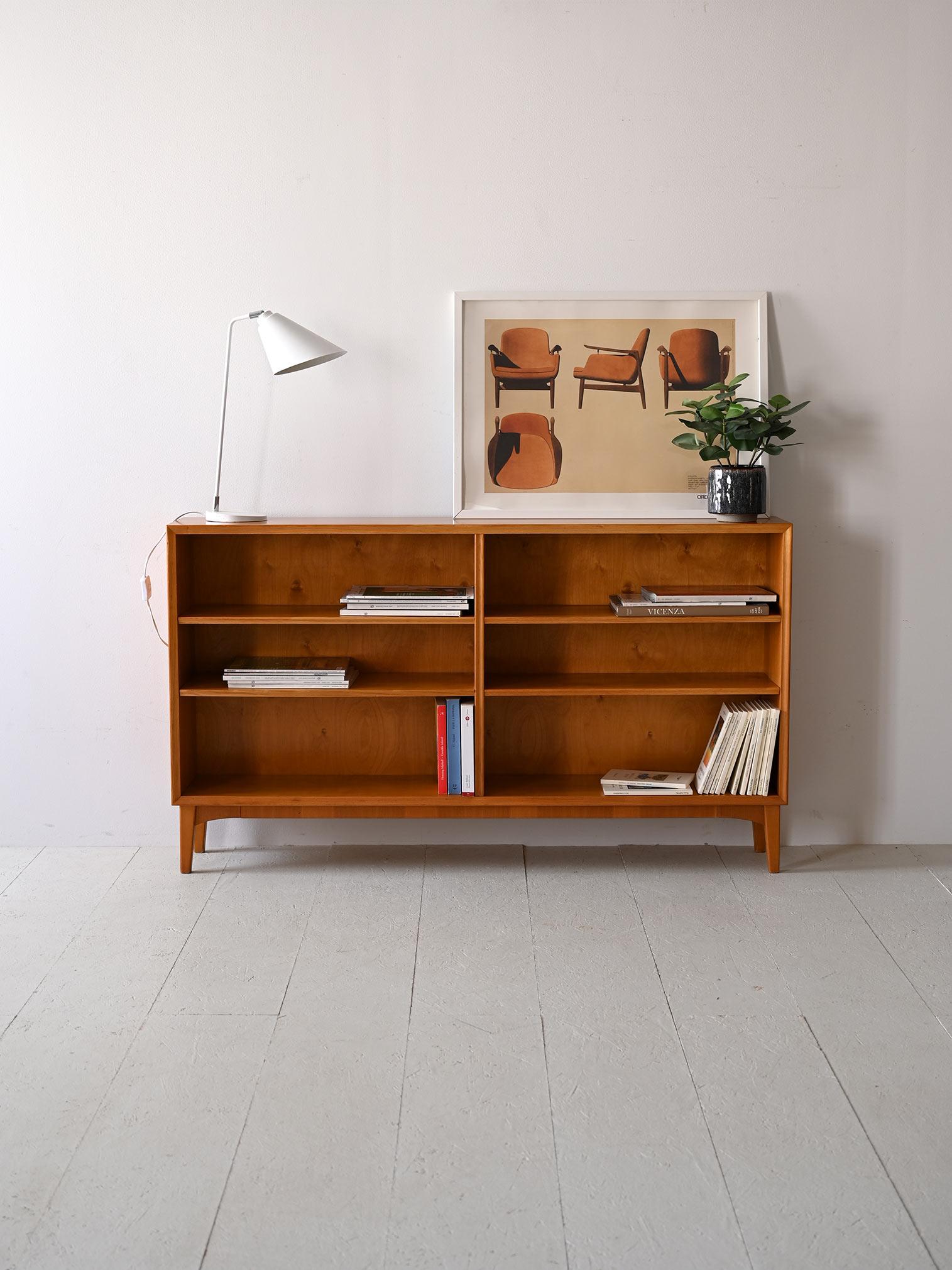 This Scandinavian bookcase, made in the 1950s, has four adjustable shelves that provide flexibility in organizing space. 
The wood, with its warm tone and natural grain, adds an element of character while maintaining a simple aesthetic.
The design