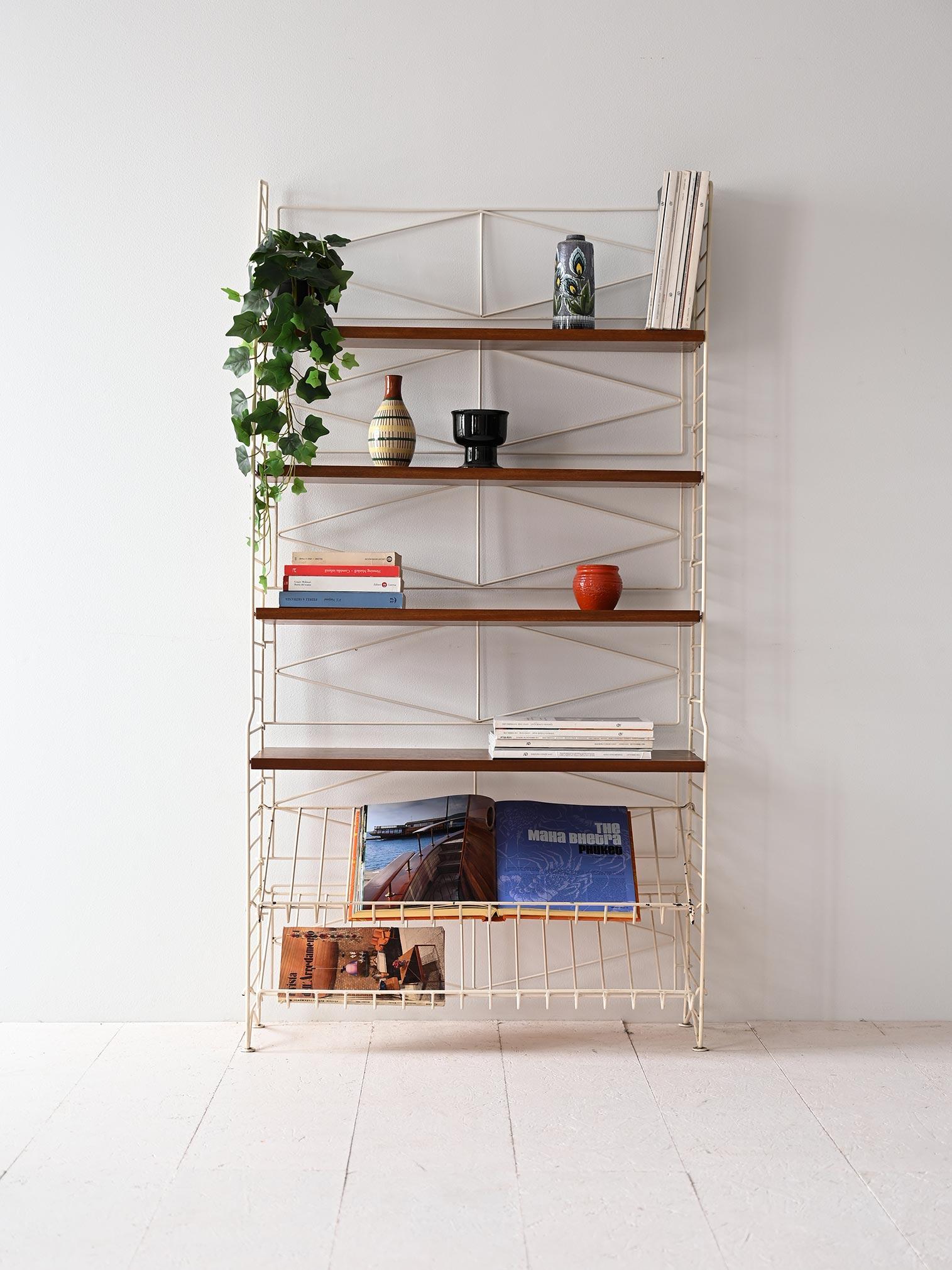 Rara libreria scandinava vintage con struttura in metallo e mensole in legno di mogano.

La struttura è formata da quattro mensole in legno e da due portariviste che si trovano nella parte bassa. La struttura in metallo dona al mobile leggerezza e