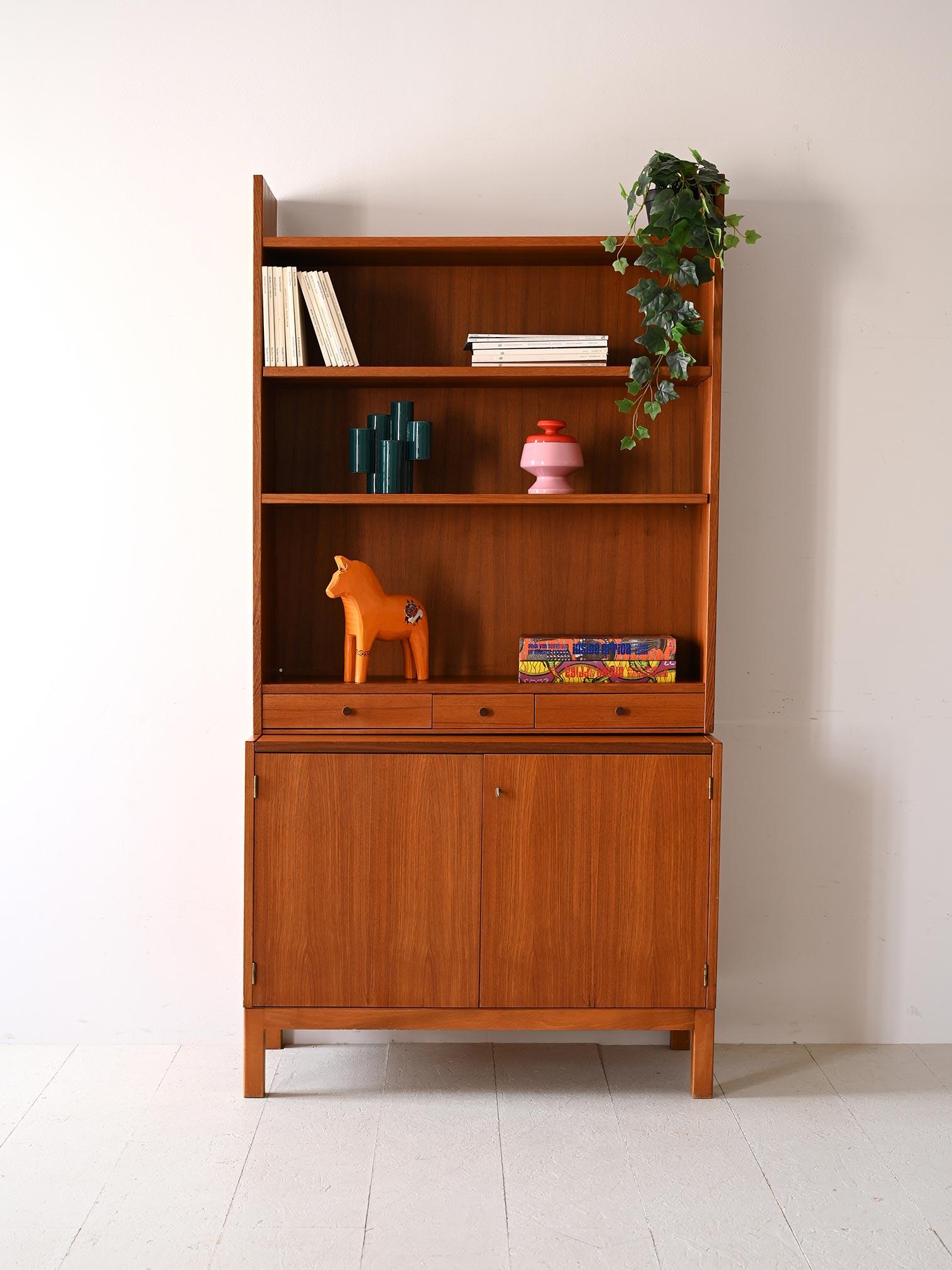 1960s cabinet open shelving and storage compartment.

This teak bookcase is an elegant and functional piece of furniture that harks back to the best Scandinavian design tradition. 
The open top provides a space for books or art supplies, while the