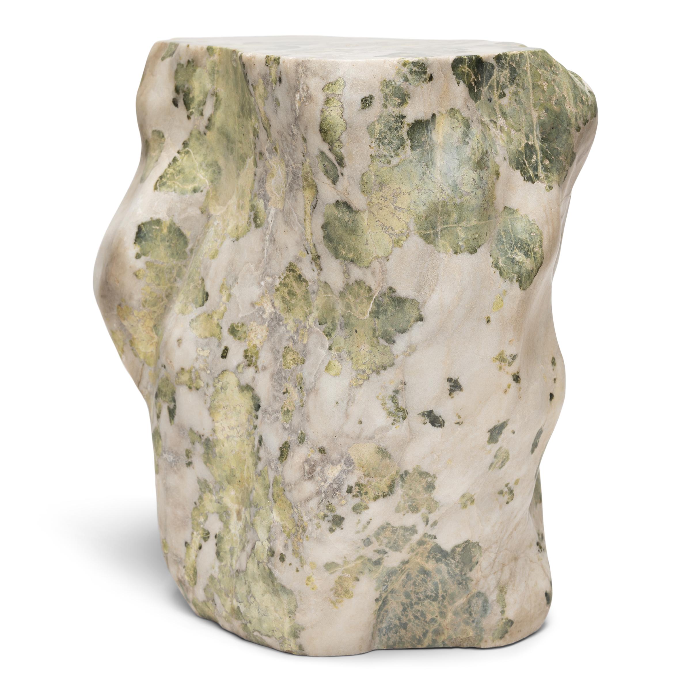This meditation stone stool was carefully selected for its biomorphic shape and beautiful, organic patterning. The stone is comprised of white-grey marble flecked with flower-like inclusions of jadeite, agate and serpentine, resembling a bloom of