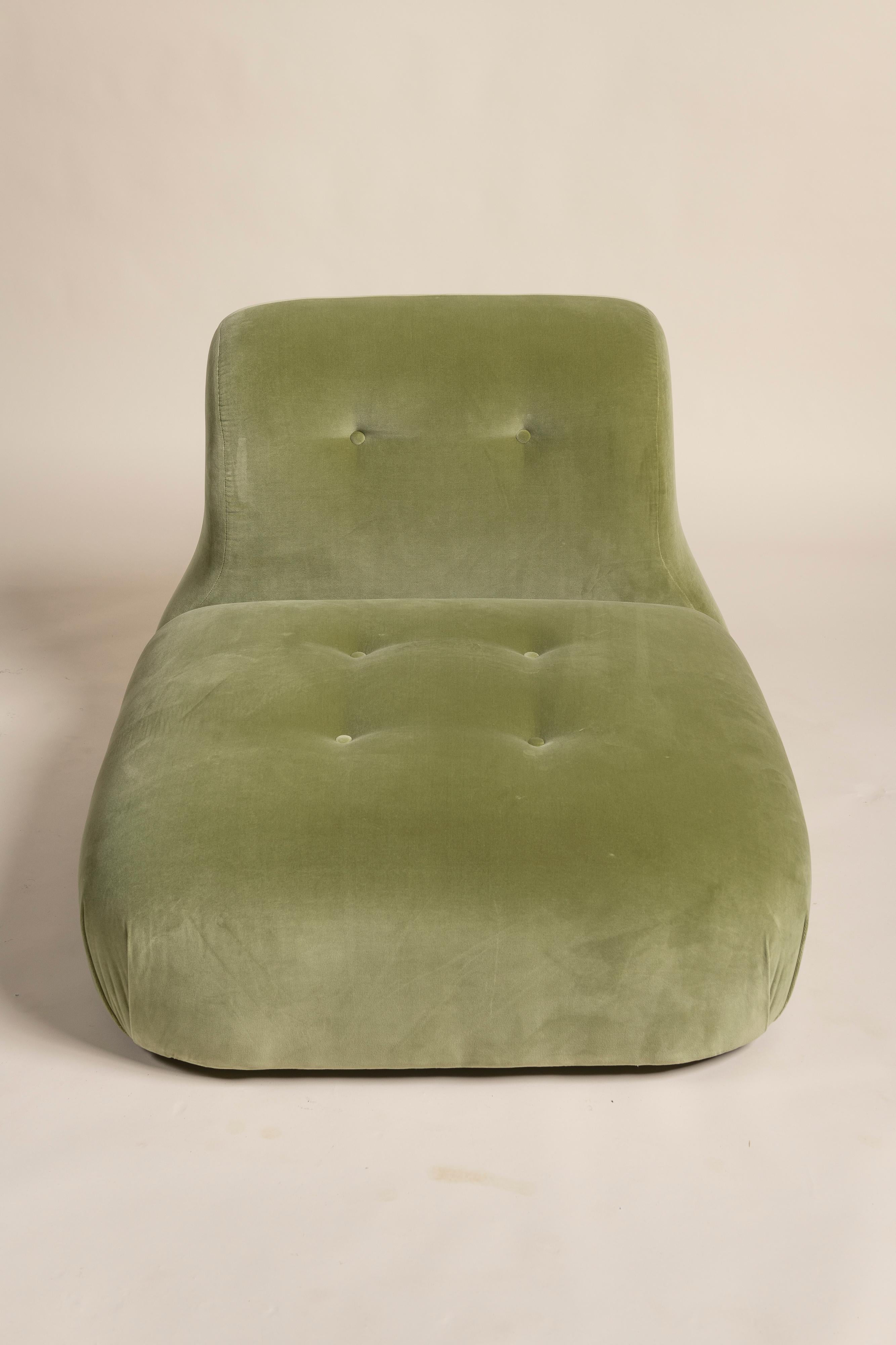 This House of Hackney lounge chair combines relaxed elegance with bold design. Upholstered in velvety, earthy green fabric, it features a low, wide seat and a softly curved, padded backrest.

Tufted button details add classic texture, while its