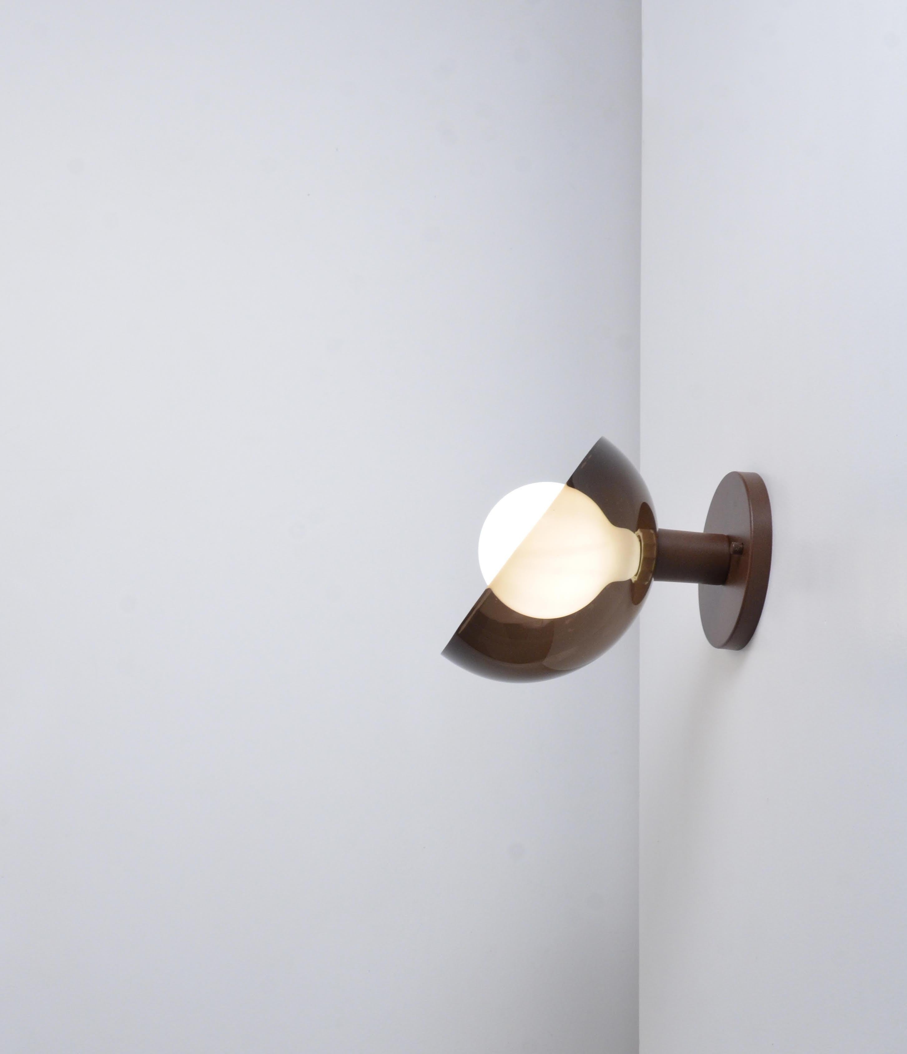 The Lichia sconce has a modern design. It's structure is made of polished, brushed or aged brass. It also has one light difusor in a round shape, made of acrylic, which can be the colors milky, nude, smoked or black, where there's a translucent