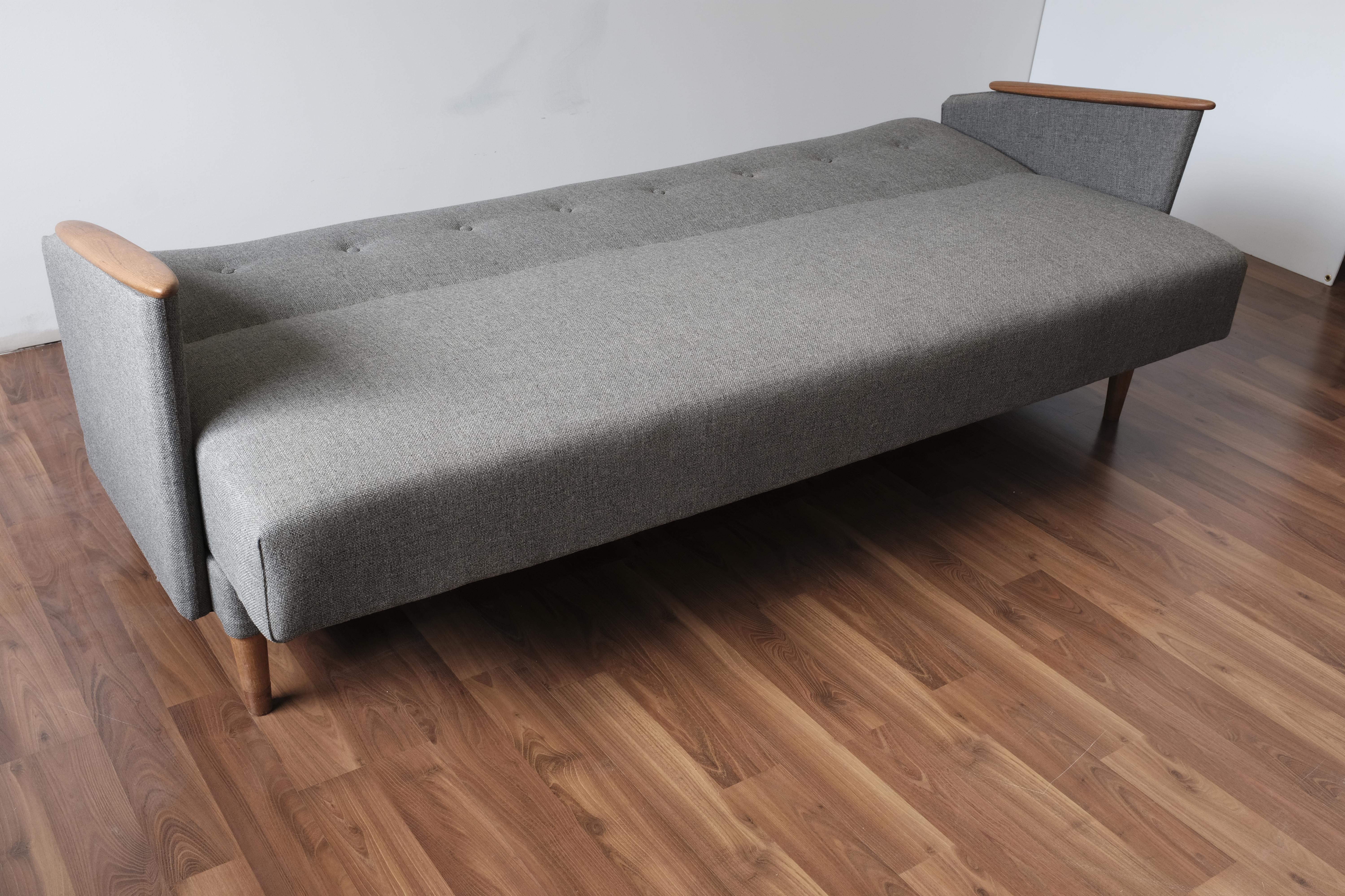 Sofa-bed or daybed with new grey upholstery and refinished teak armrests and legs. 

The mattress surface measures 73