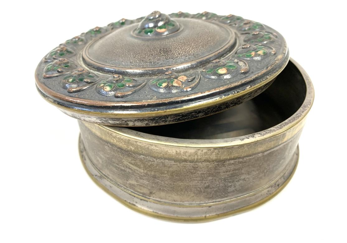 Manufactured by Orfevrerie Jacob (Henri Jacob) - Geneva / Switzerland lidded box with relief enamel flowers on a textured ground. The interior with a fabric lined lid. Stamped on verso with maker's mark.
Dimensions: 7 1/4
