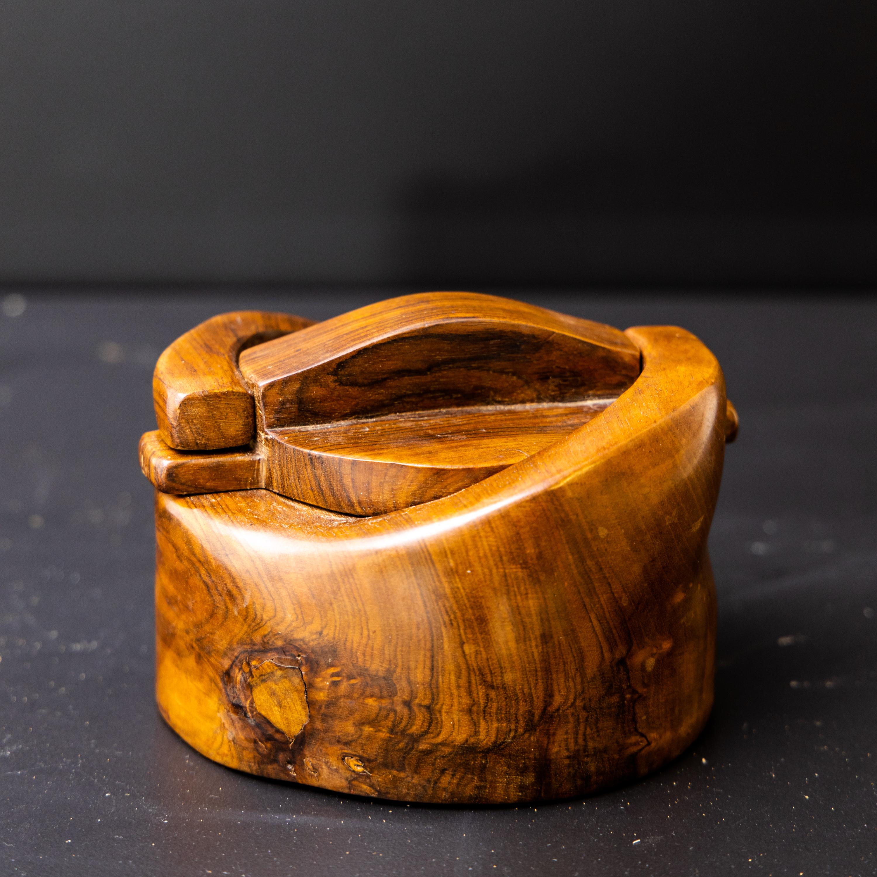 Exquisitely carved lidded box by Alexandre Noll (1890-1970), created around 1950. The walnut wood exhibits a smooth, polished finish, retaining its natural charm. The lid securely fastens with a small twisting movement, showcasing exceptional