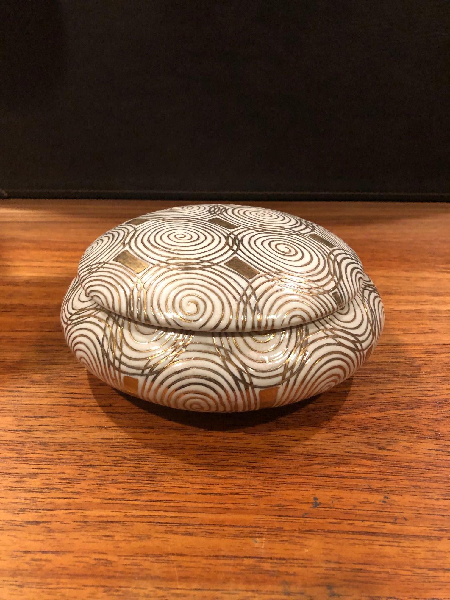 Gorgeous and rare gold and white Art Deco inspired porcelain lidded box by Jay Spectre for Silvestri, circa 1991. The piece is signed and dated 1991 on underside. The Smithsonian Institute named Jay Spectre one of its top ten designers of the 20th