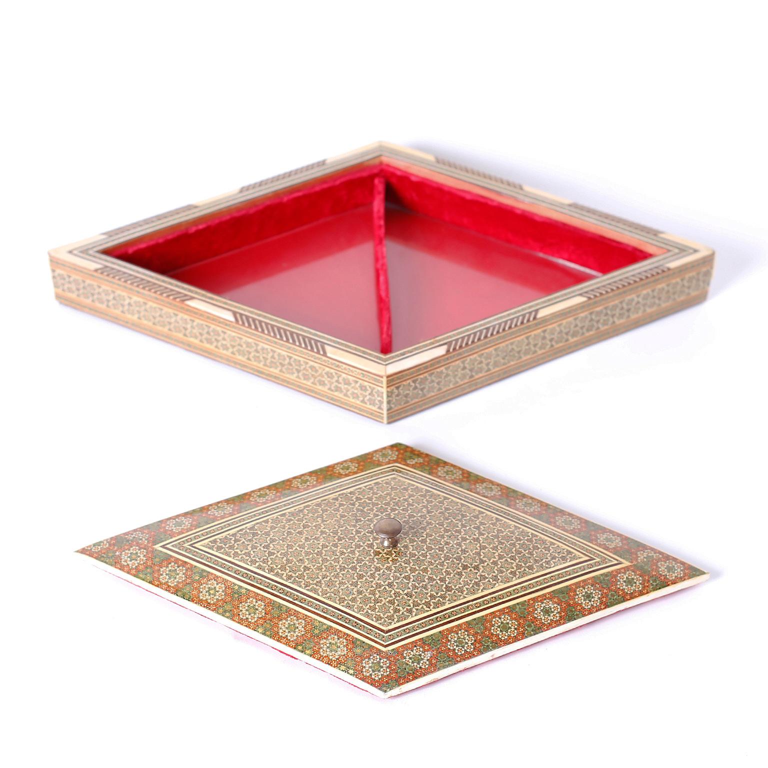 Anglo Indian jewelry box with a diamond form decorated with intricate geometric marquetry in bone, mother of pearl, and exotic woods. The interior is lined with red velvet and lacquer under glass.