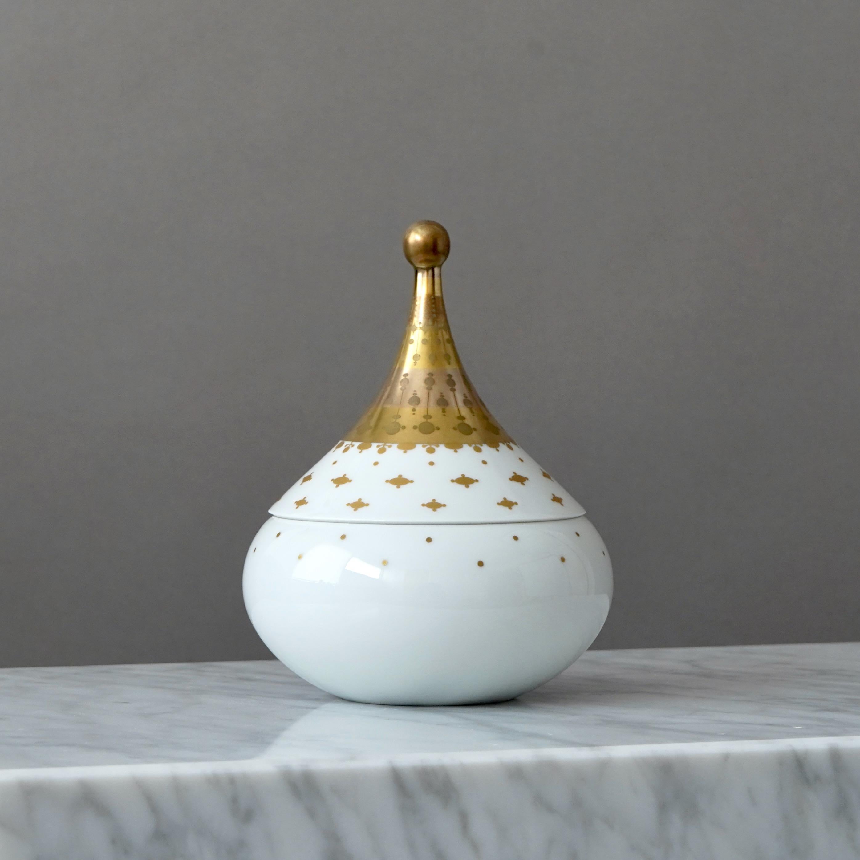 Una preciosa caja de baratijas de porcelana con asombrosos detalles dorados pintados a mano. Superficie texturada y forma de lágrima. Quatre Couleurs