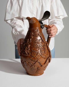 Lidded Stoneware Jug With Raised Grape Vine Decoration