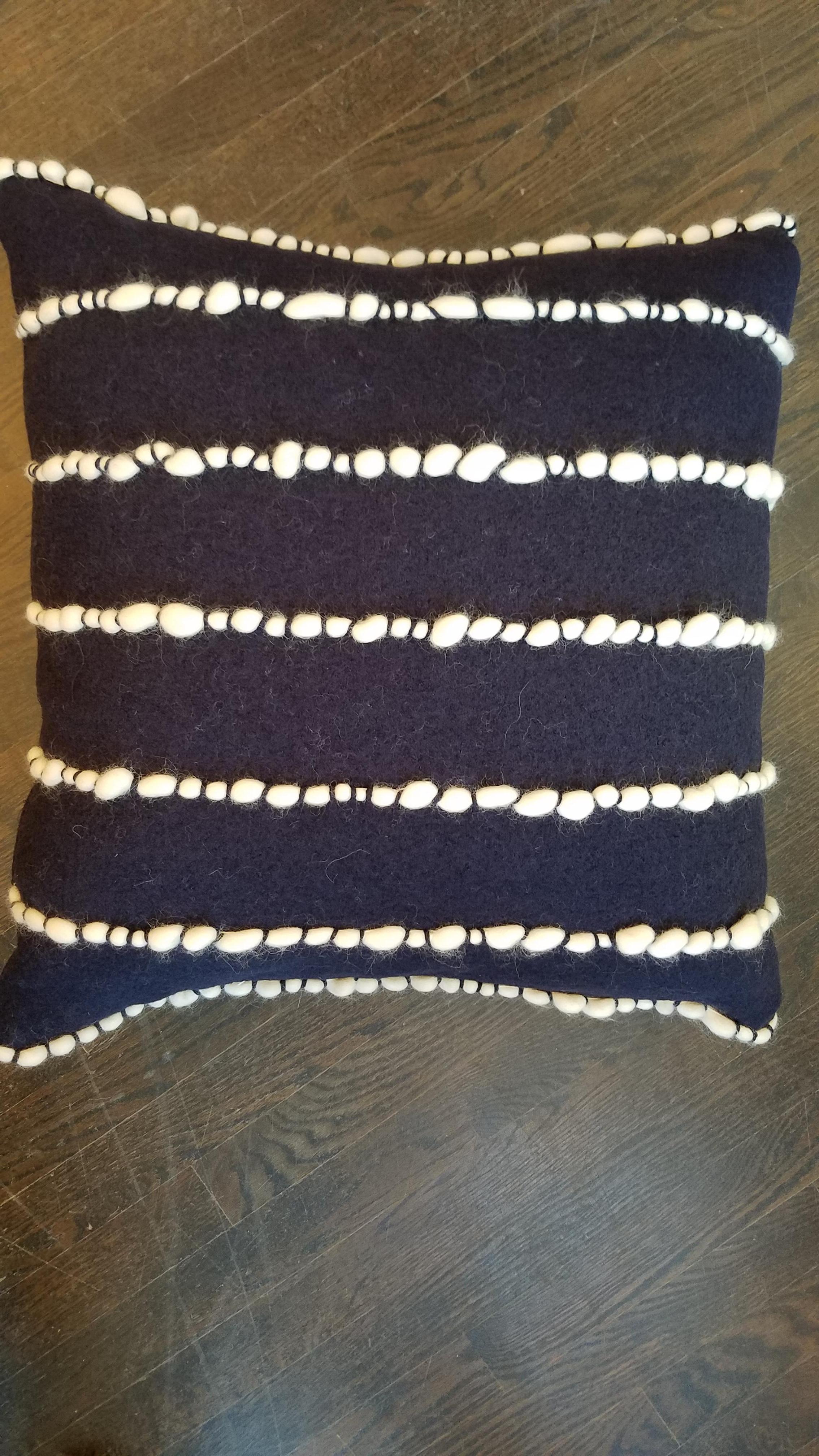 100% merino wool handwoven, hand-channeled and tufted, navy blue pillow with feather/down insert and concealed zipper. Made in Italy.
