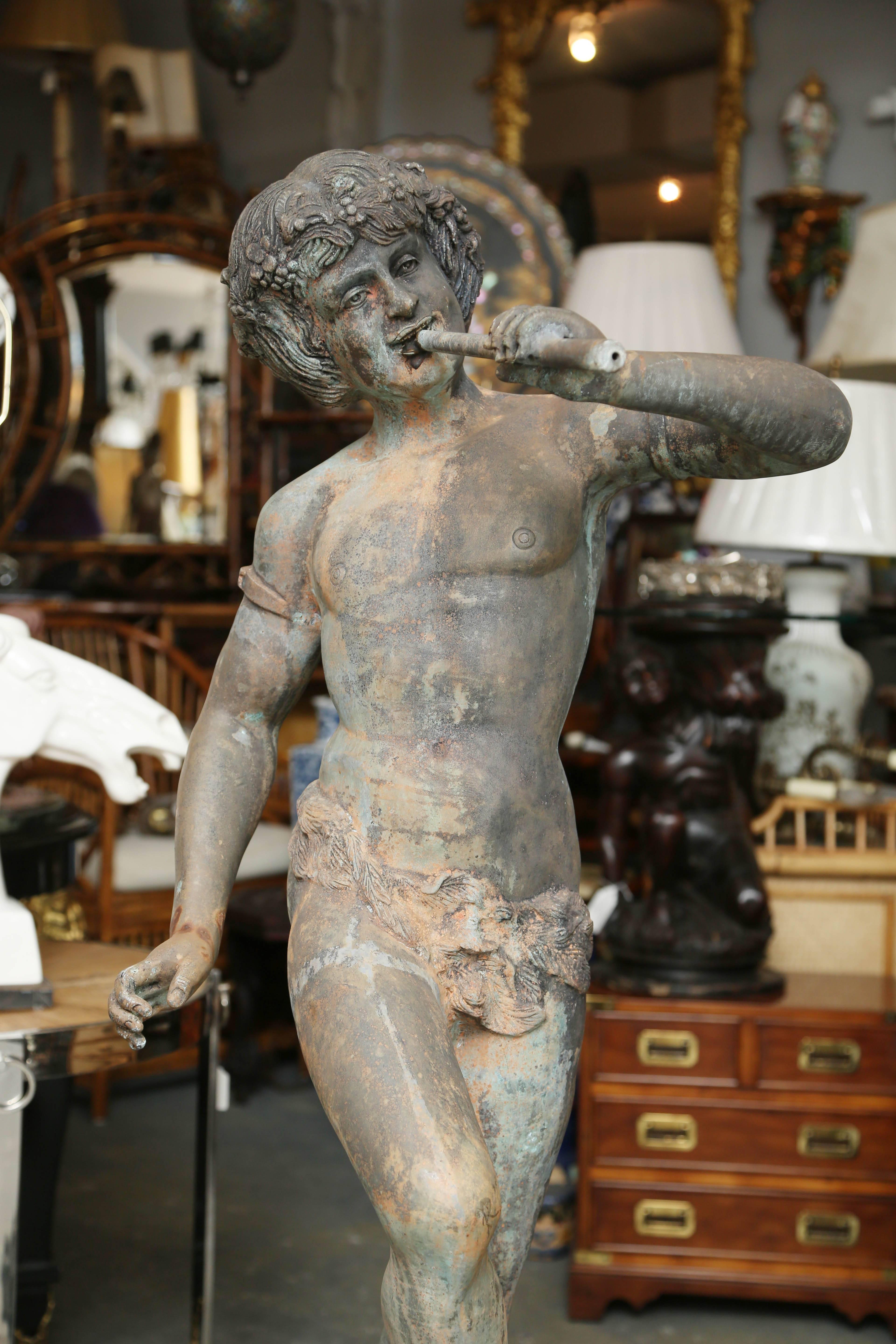 A fine figure of a youth playing a flute and standing on a large shell.
The face is expressive, and both his hands and feet are well formed.
A well posed Greco-Roman figure.

 