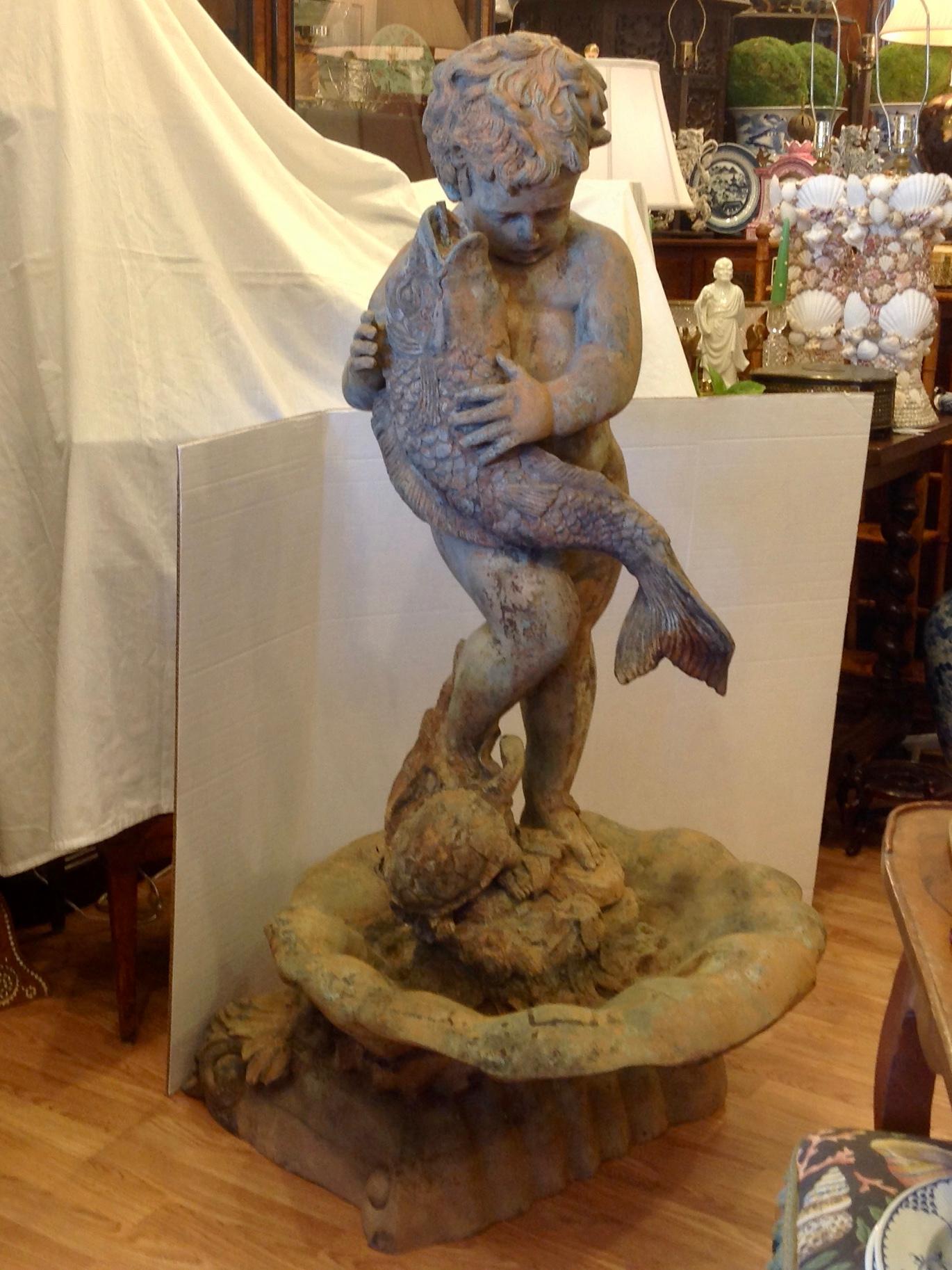 Outstanding design fashioned as a boy struggling to hold a fish. 
The boy is standing on a 